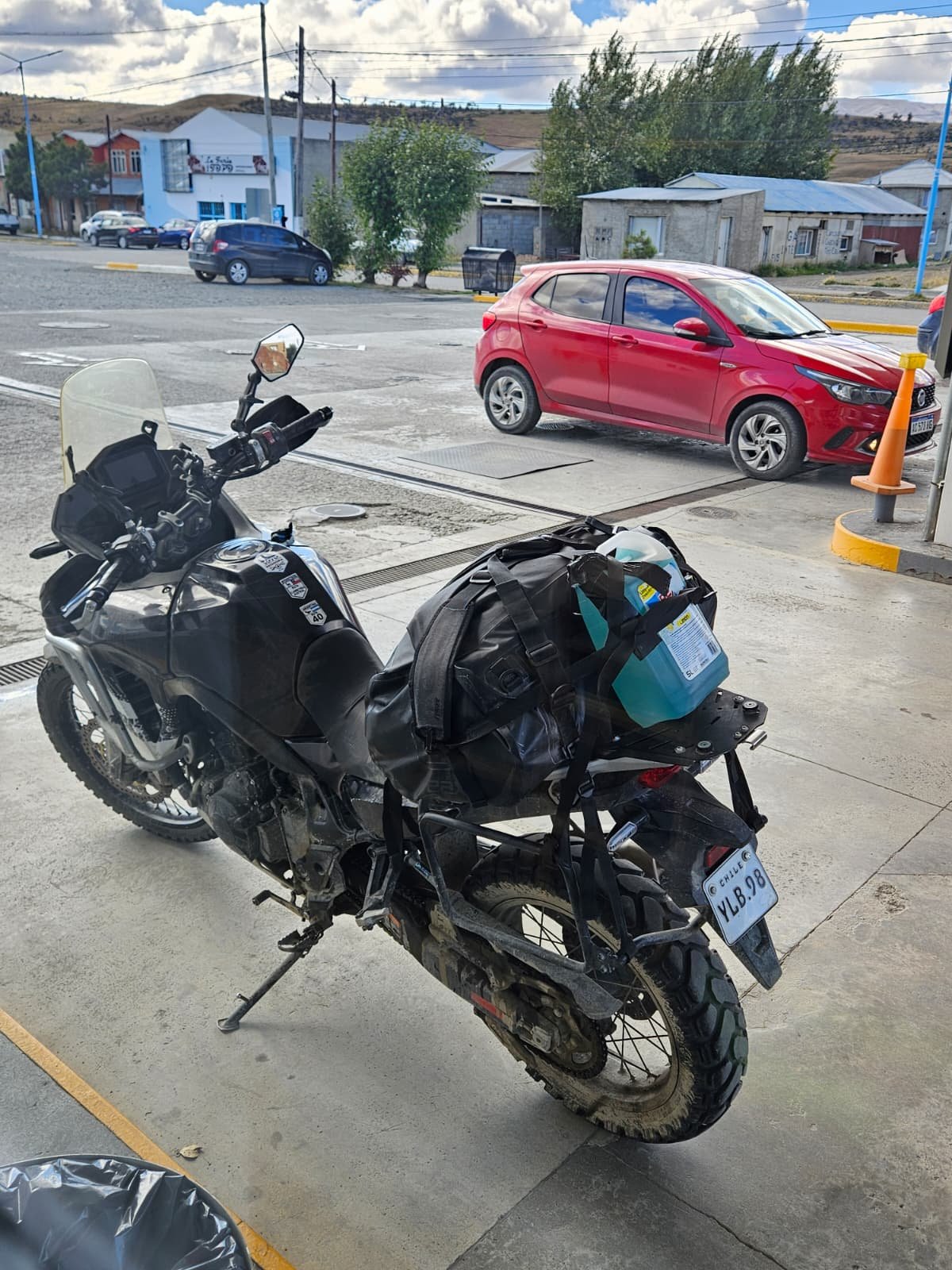 ADV motorcycle at a gas station with a homemade jerrycan strapped on that looks like Gatorade.