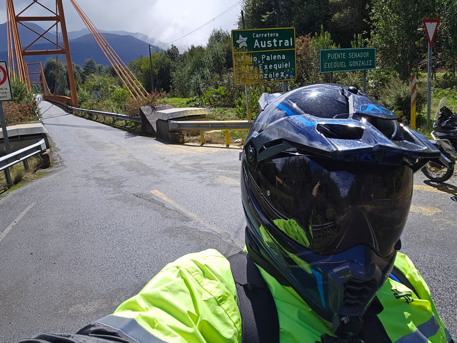 ADV motorcyclist in helmet in front of famous bridge on the Carretera Austral