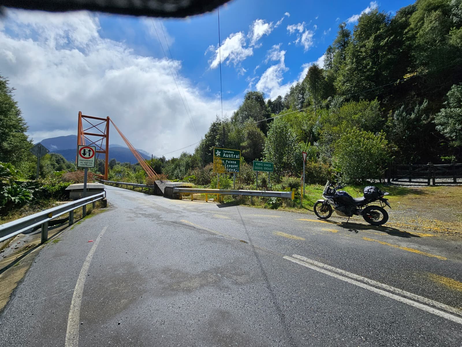 ADV motorcycle parked by famous bridge on Carretera Autral Chile.