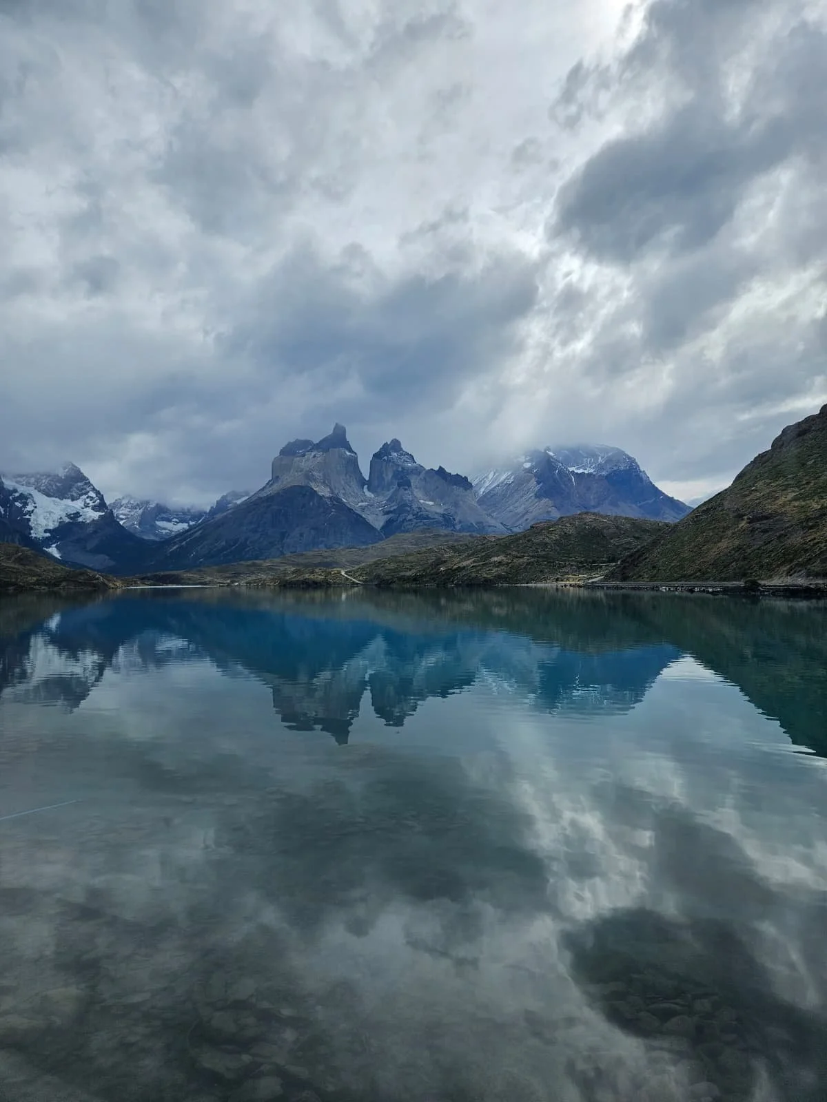 Dramatic cloudy sky reflecting on the blue lake water of Caleta Tortel.