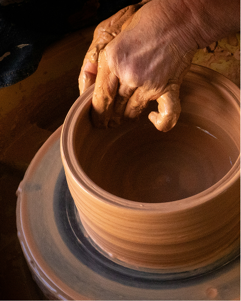 Two hands holding a finished, hand-made vessel