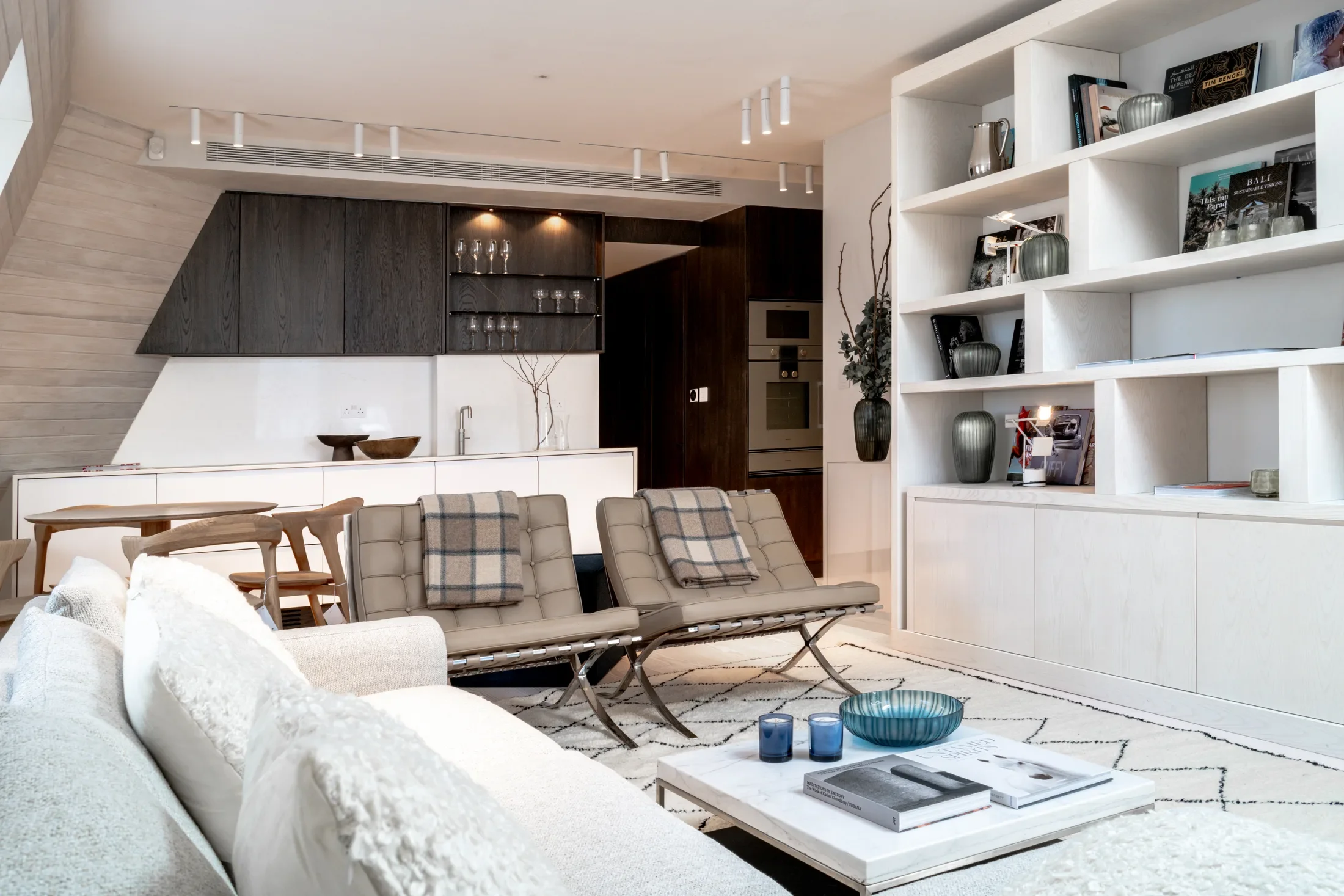 Open-plan living and dining room with display shelving — AKC Asset Management real estate, part of AKC Group.