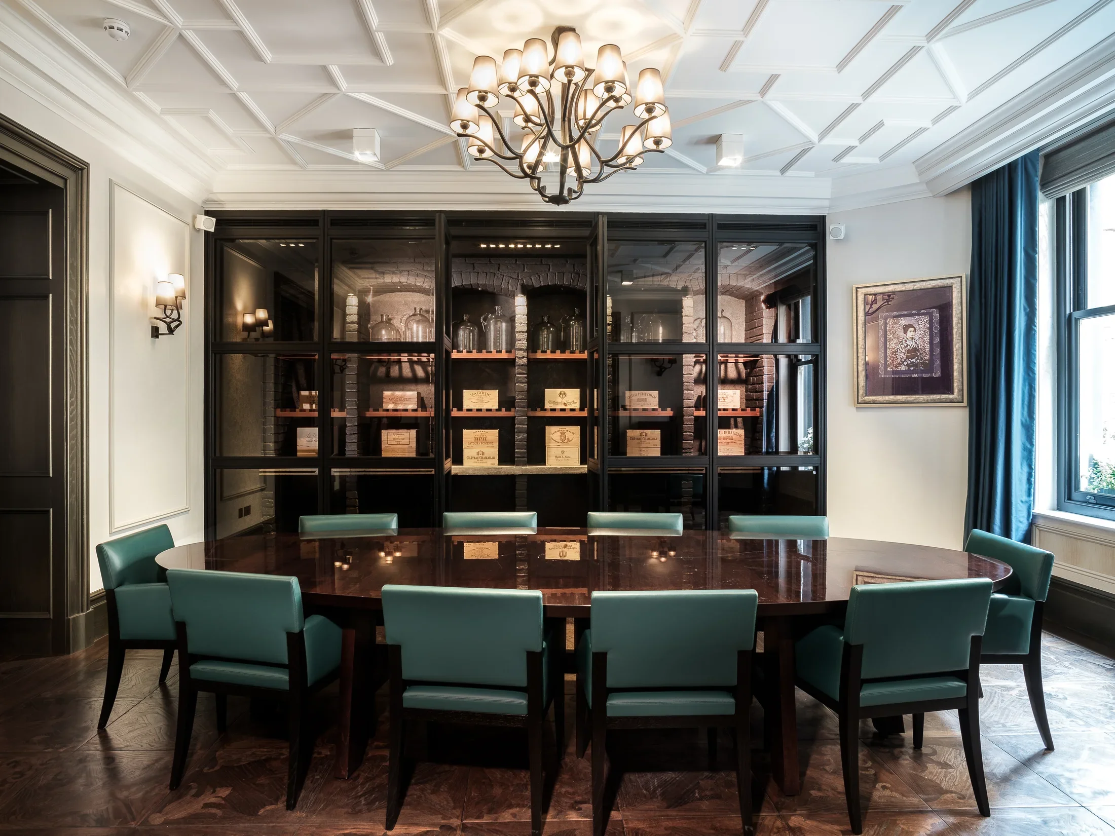 Dining room with green chairs and illuminated library shelving — AKC Asset Management real estate, part of AKC Group.
