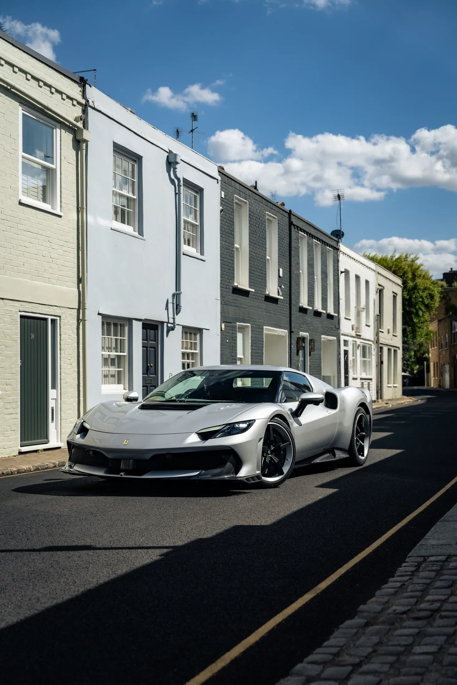 Ferrari 296 Speciale in Argento Nürburgring — Beside painted terraced houses — AKC Asset Management.