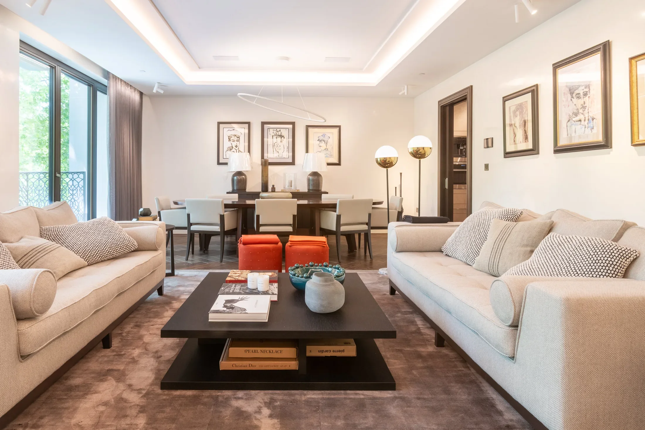 Living room with pale sofas and a central coffee table — AKC Asset Management real estate, part of AKC Group.