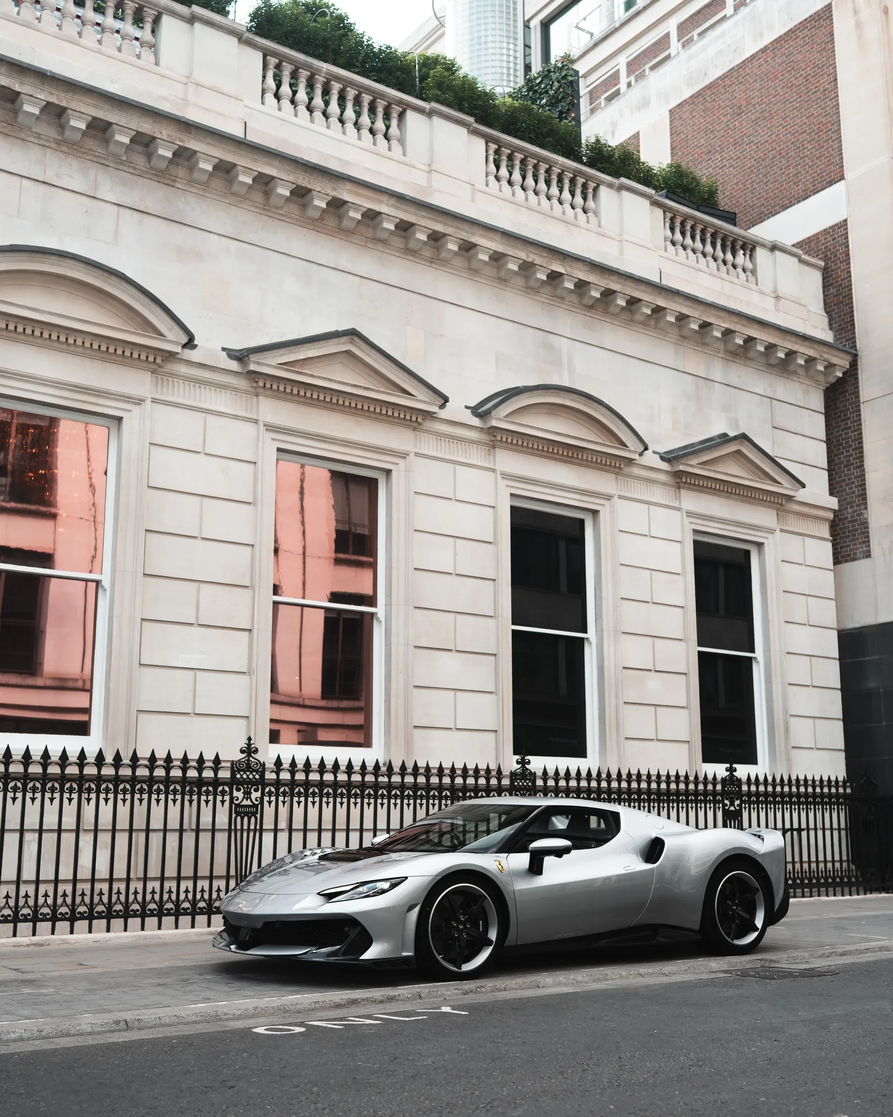 Ferrari 296 Speciale in Argento Nürburgring — Beside a classical stone facade — AKC Asset Management.