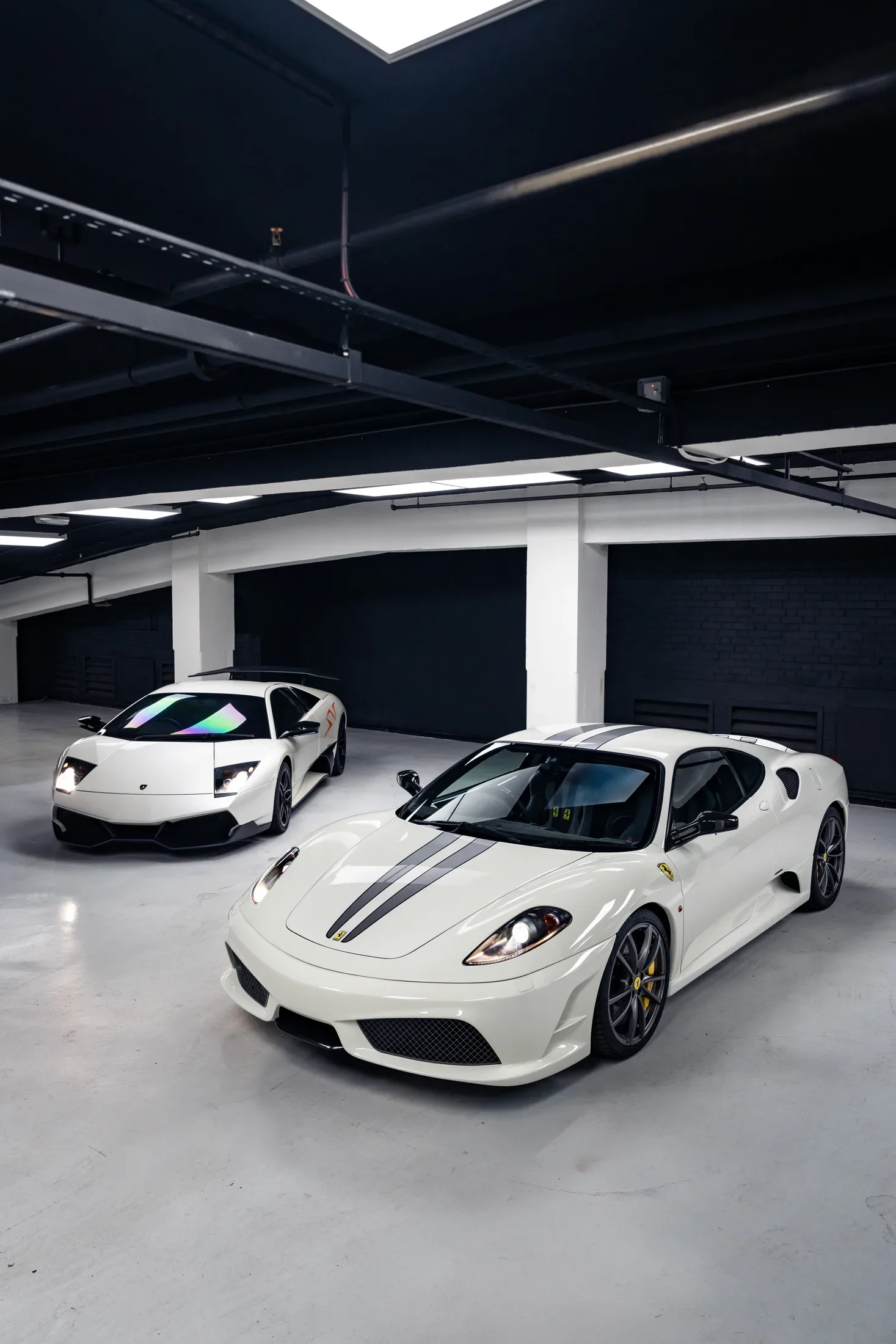 Ferrari and Lamborghini together in a private garage — AKC Asset Management.