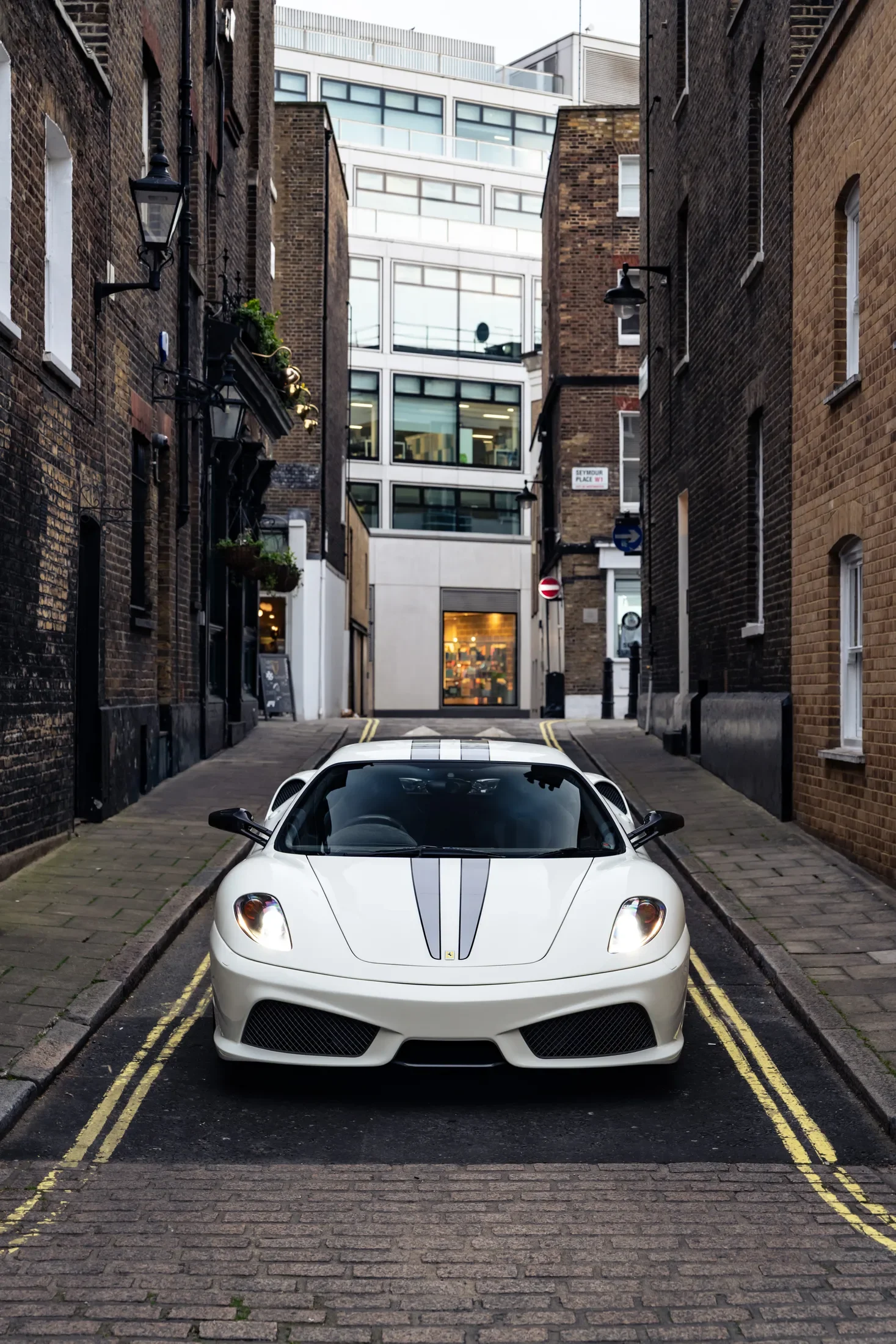 Ferrari 430 Scuderia in Bianco Avus — Front view on a narrow street — AKC Asset Management.