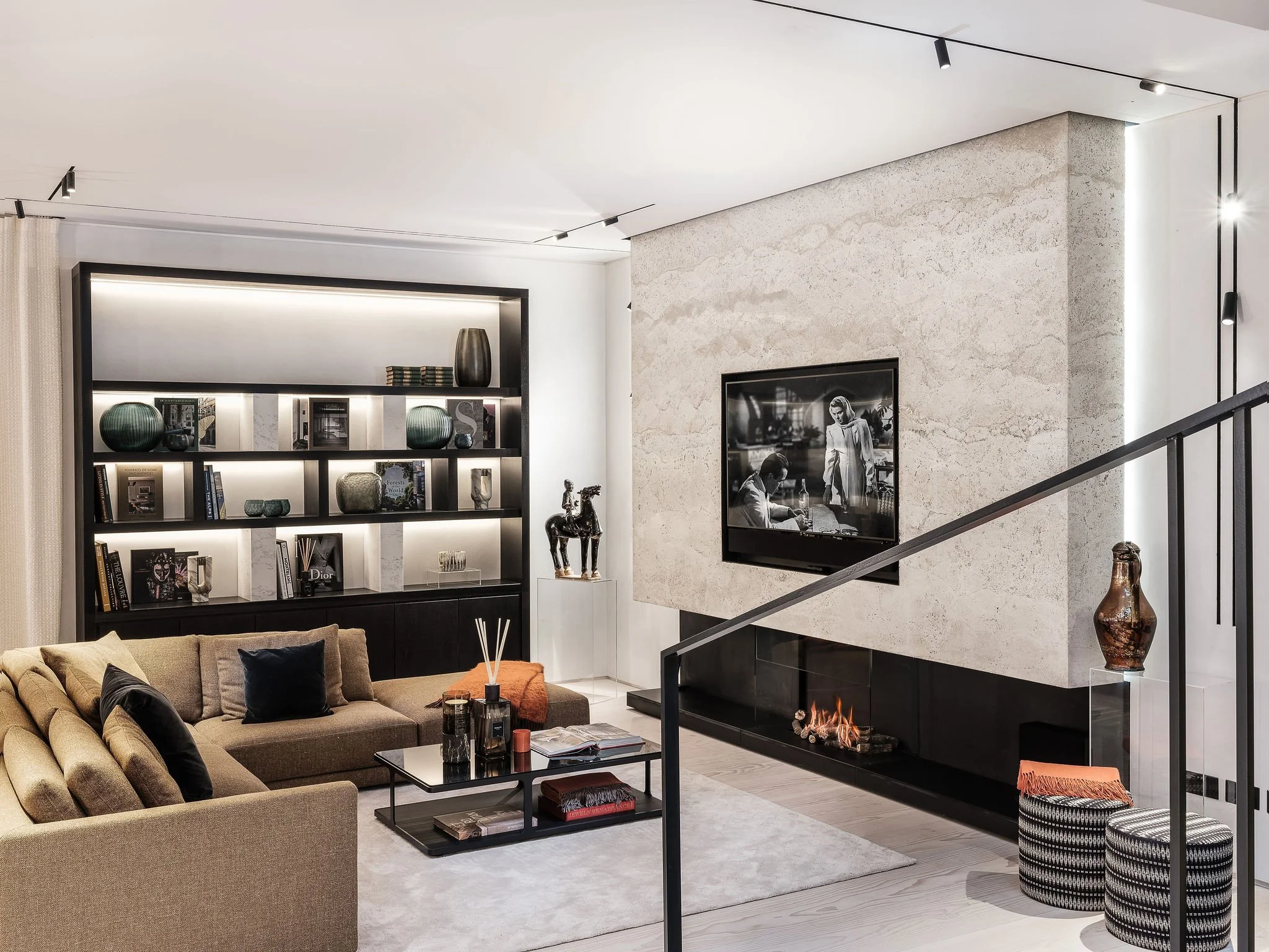 Contemporary living room with a fireplace, artwork and display shelving — AKC Asset Management real estate, part of AKC Group.