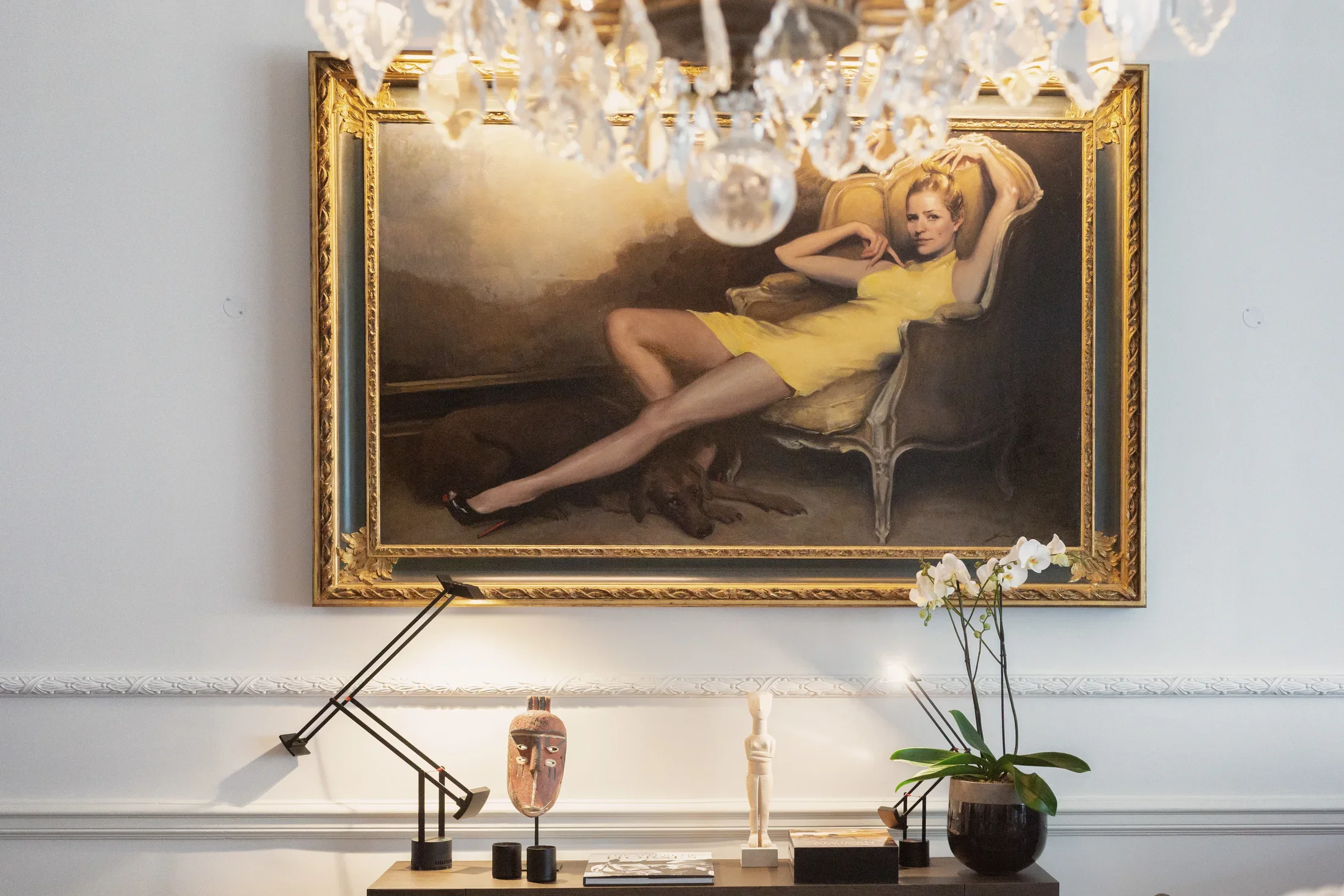 Framed portrait of a reclining woman above a console table — AKC Asset Management art collection services.