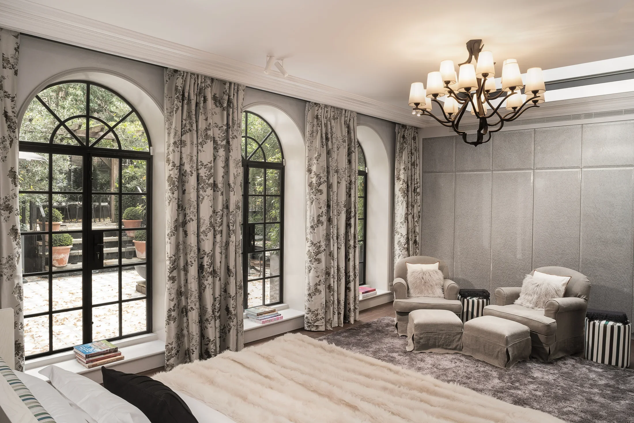 Light-filled room with arched windows and a chandelier — AKC Asset Management real estate, part of AKC Group.