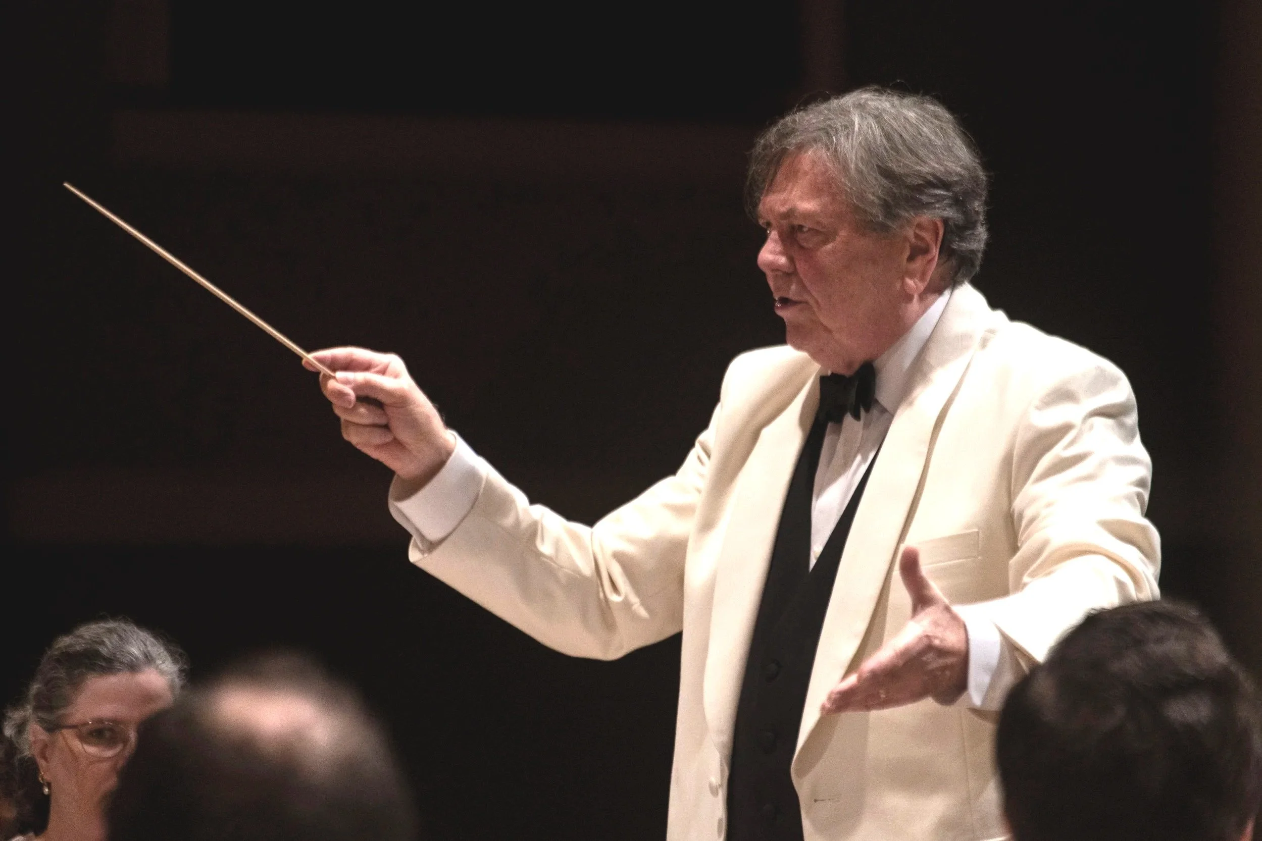 Gerard Schwarz in a white tuxedo conducting the Eastern Festival Orchestra