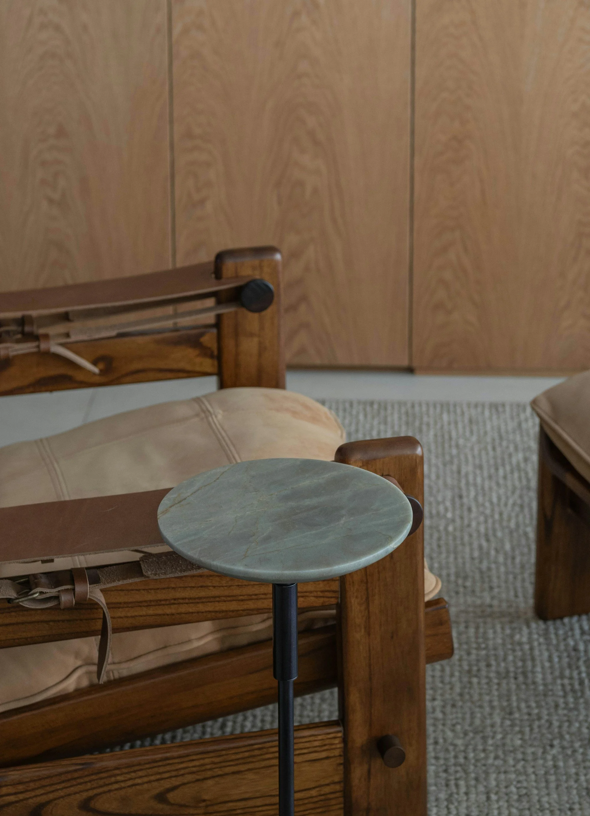 A leather lounge chair and side table in a warm contemporary interior.