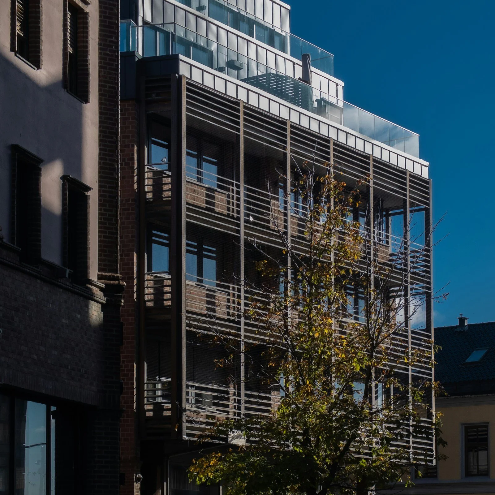 A timber-clad residential façade with repeated balconies and vertical wood detailing.