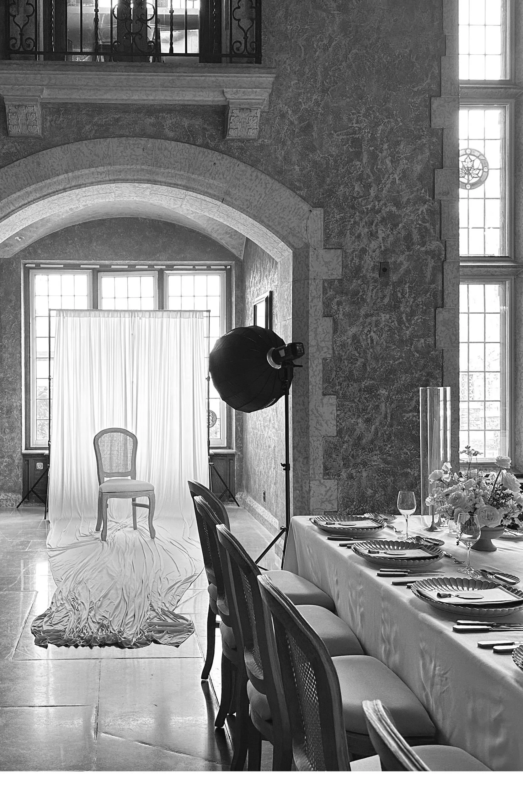 Guest portrait studio set with a white drape and cane chair beside a wedding reception table at the Fairmont Banff Springs