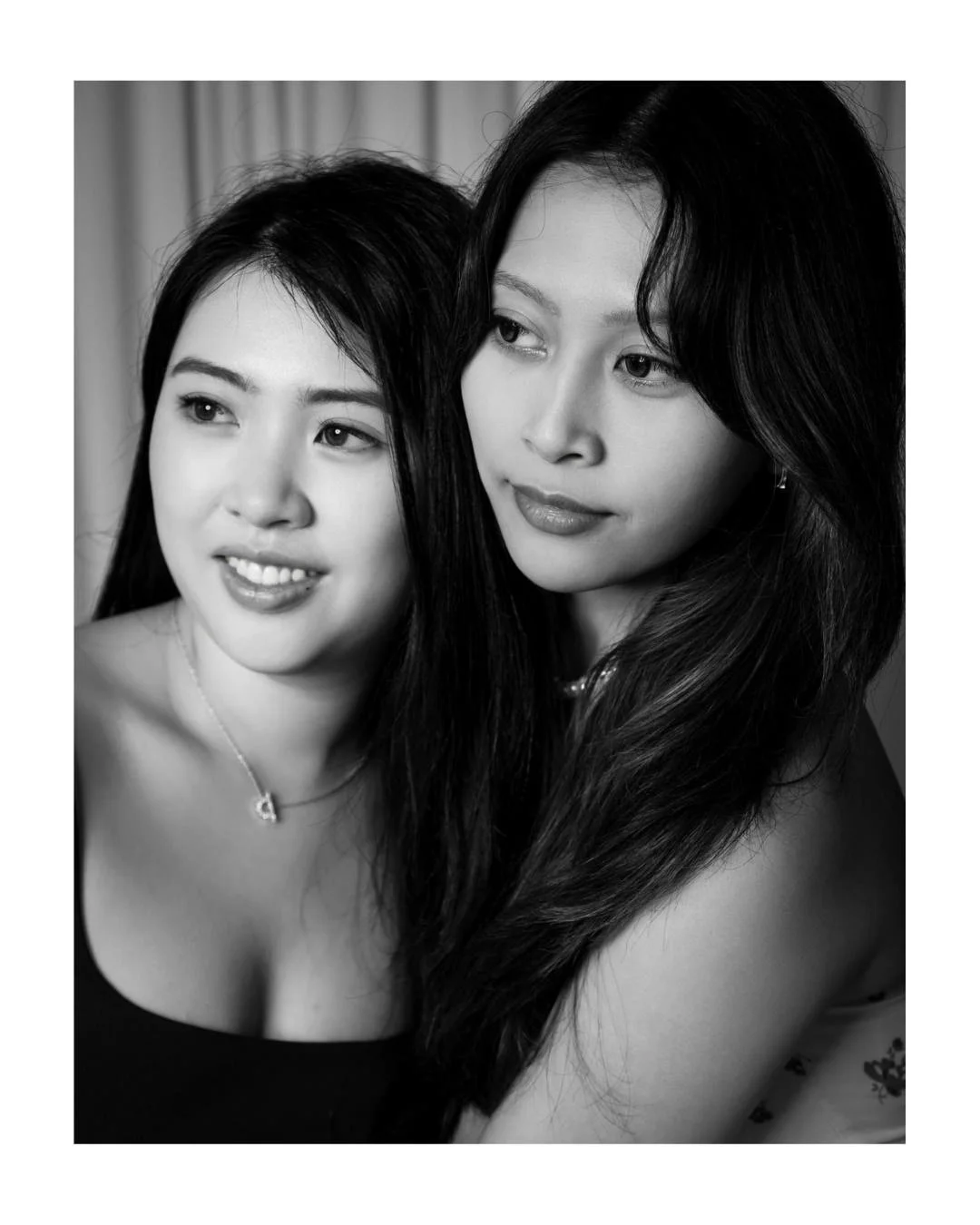 Black and white portrait of two smiling women posing close together