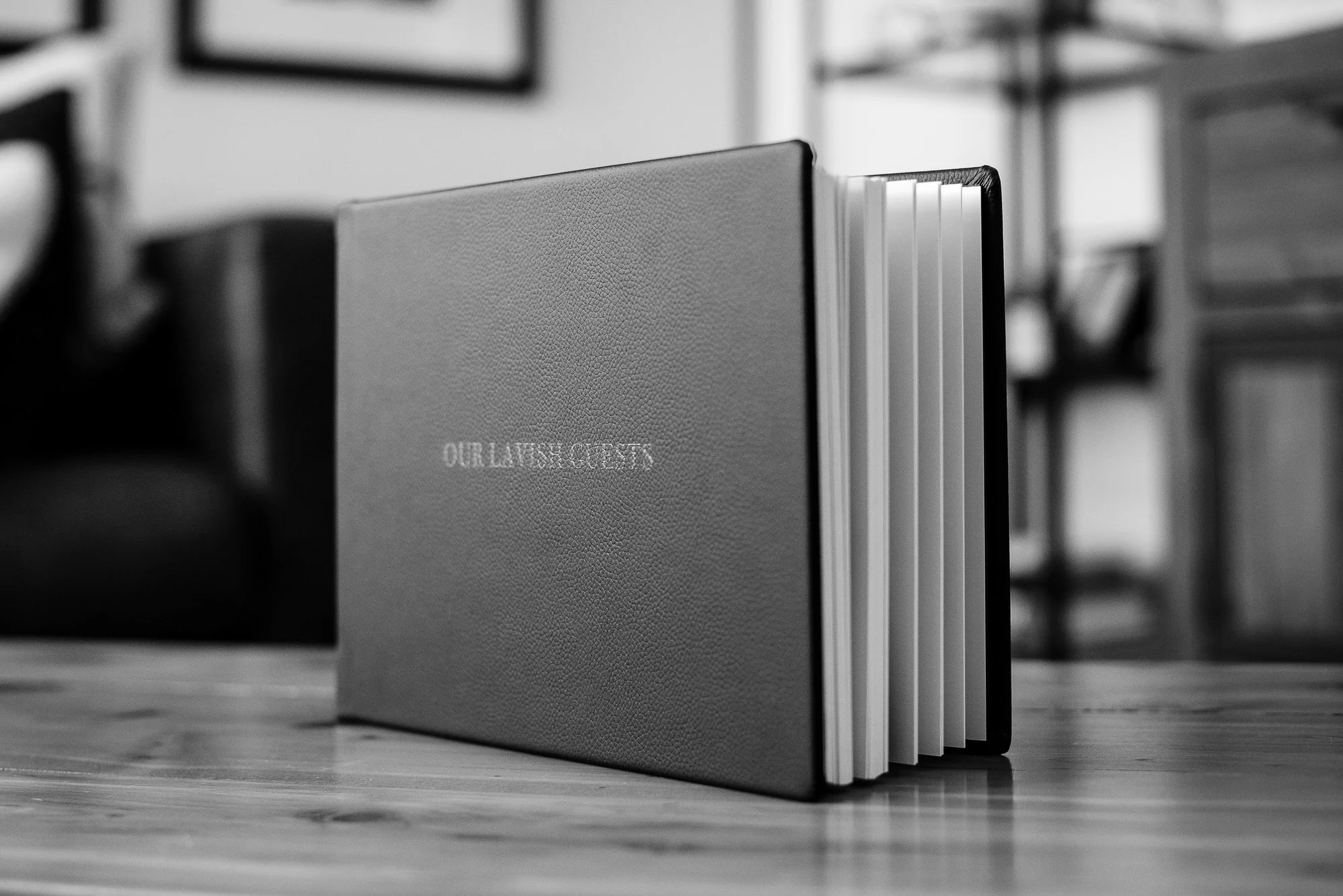 our lavish guests Guestbook cover embossed on the cover with event details and displayed in a living room setting