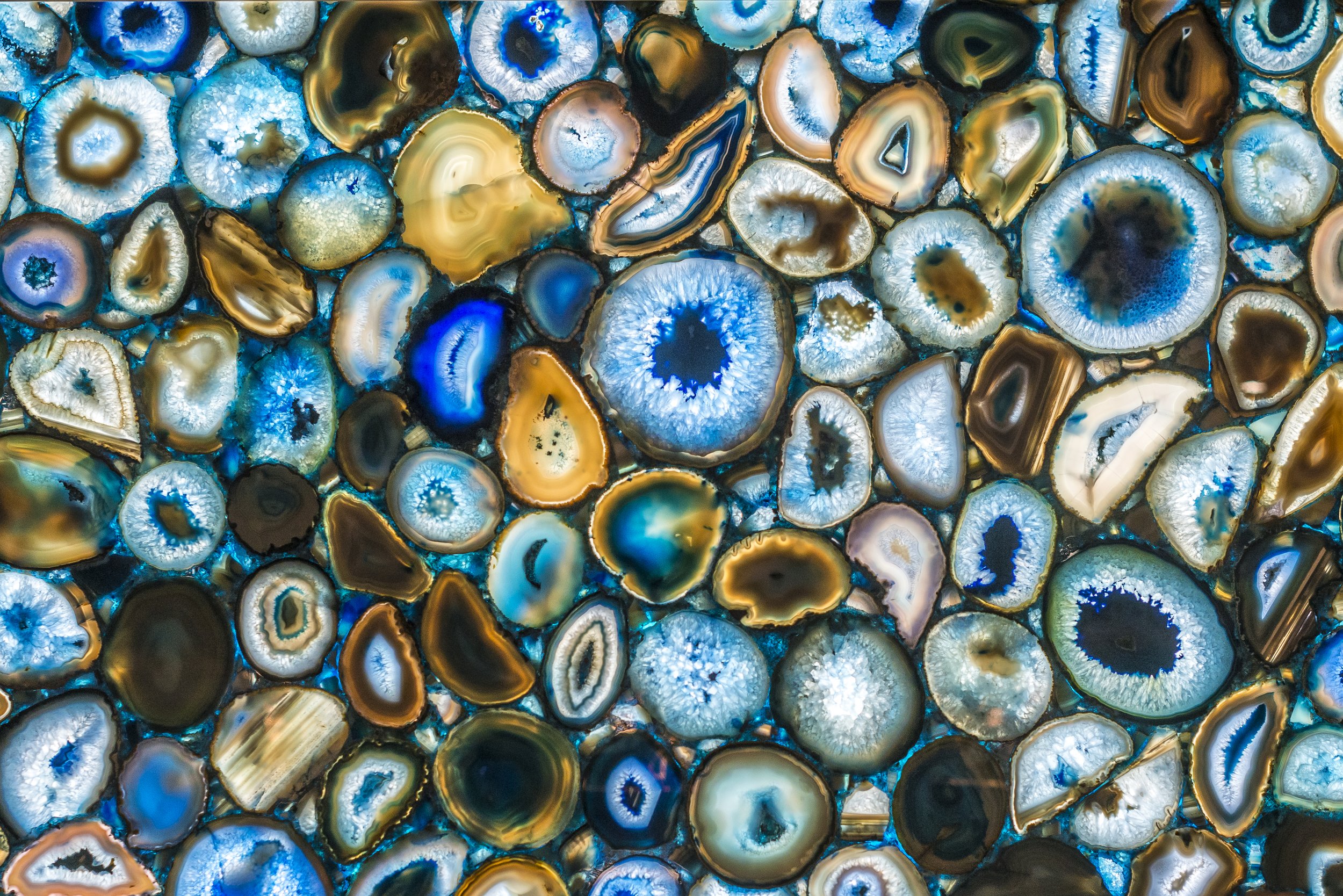 Polished agate slices in blues, golds and browns, each with its own rings formed in layers over time