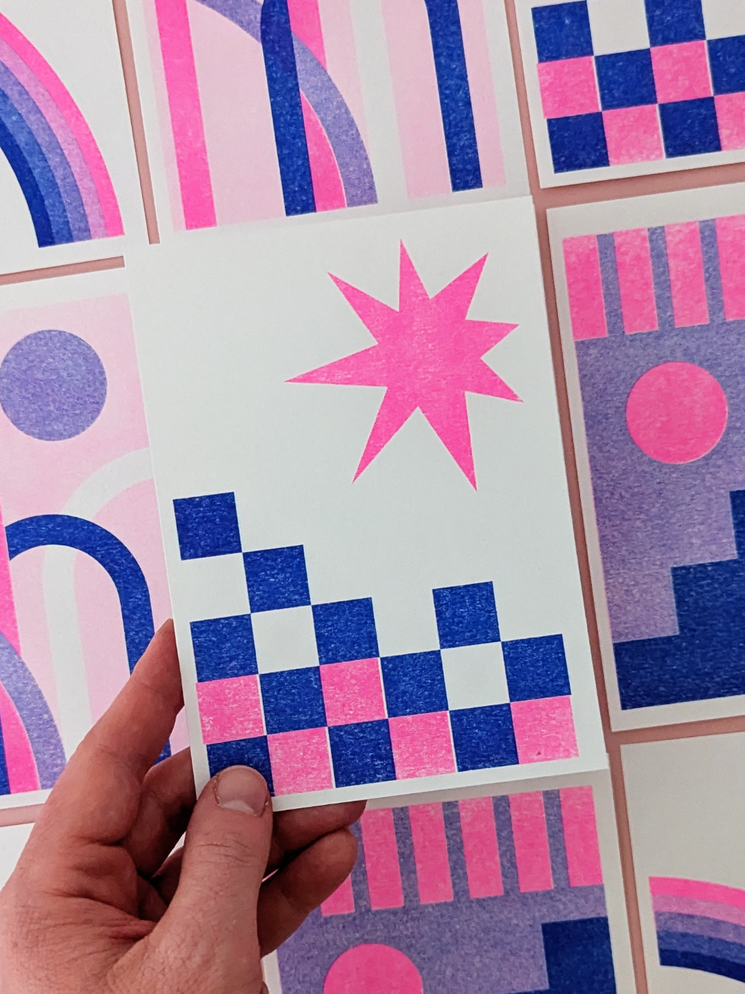 A selection of colourful, abstract prints featuring geometric shapes such as squares, triangles, circles and arcs. The prints feature vivid colours such as blue, purple and pink.