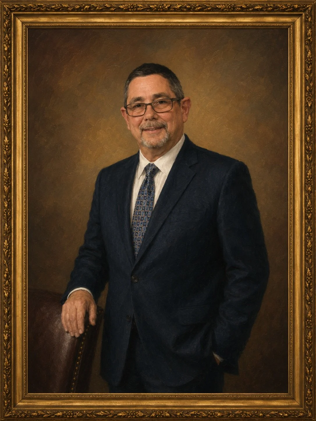 A middle-aged man dressed in a dark suit and patterned tie, wearing glasses, standing in front of a brown background, with his hand resting on a leather chair, framed by an ornate gold frame.