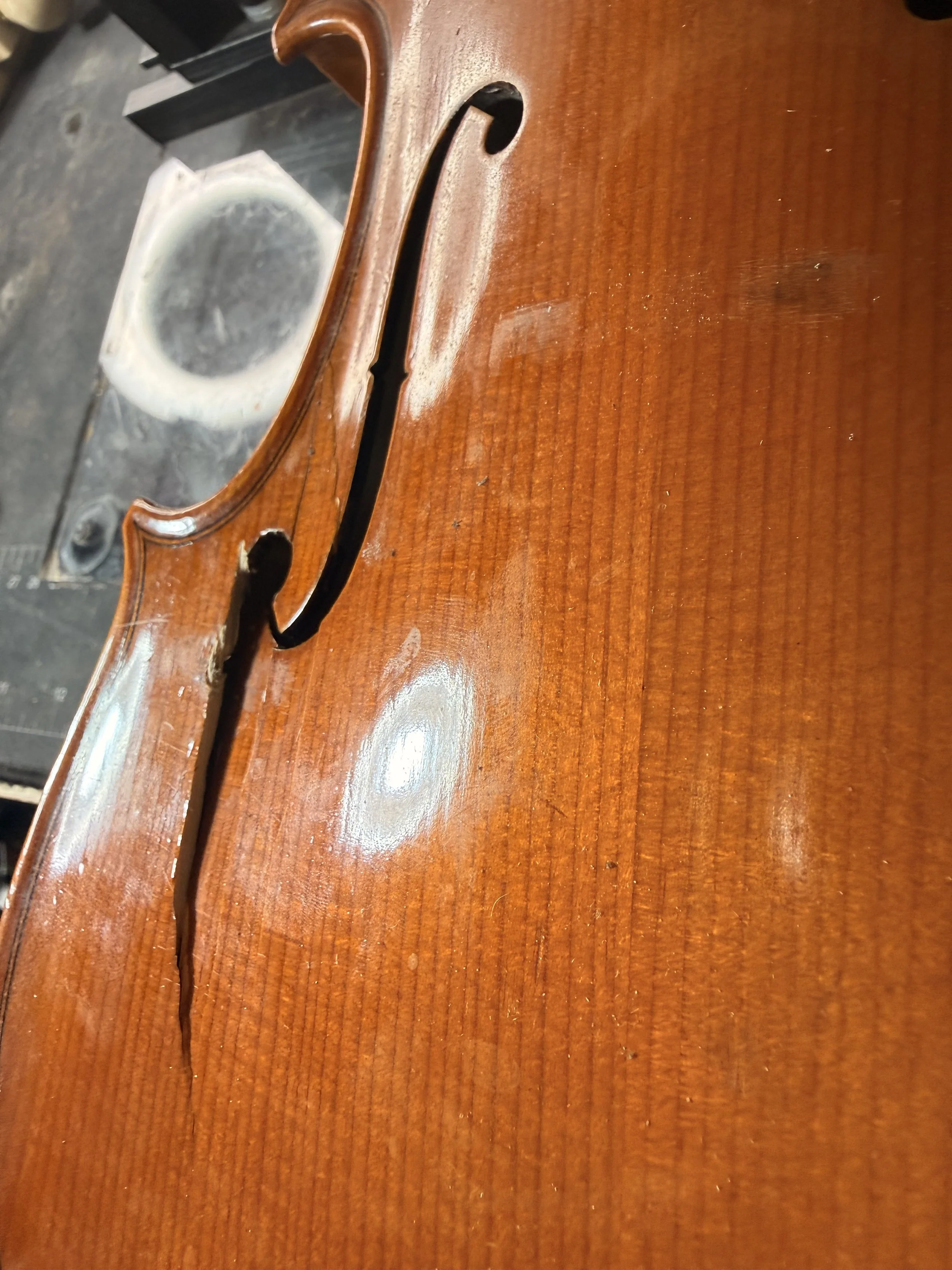 Close-up of a wooden table with a missing drawer, revealing the hollow inside.