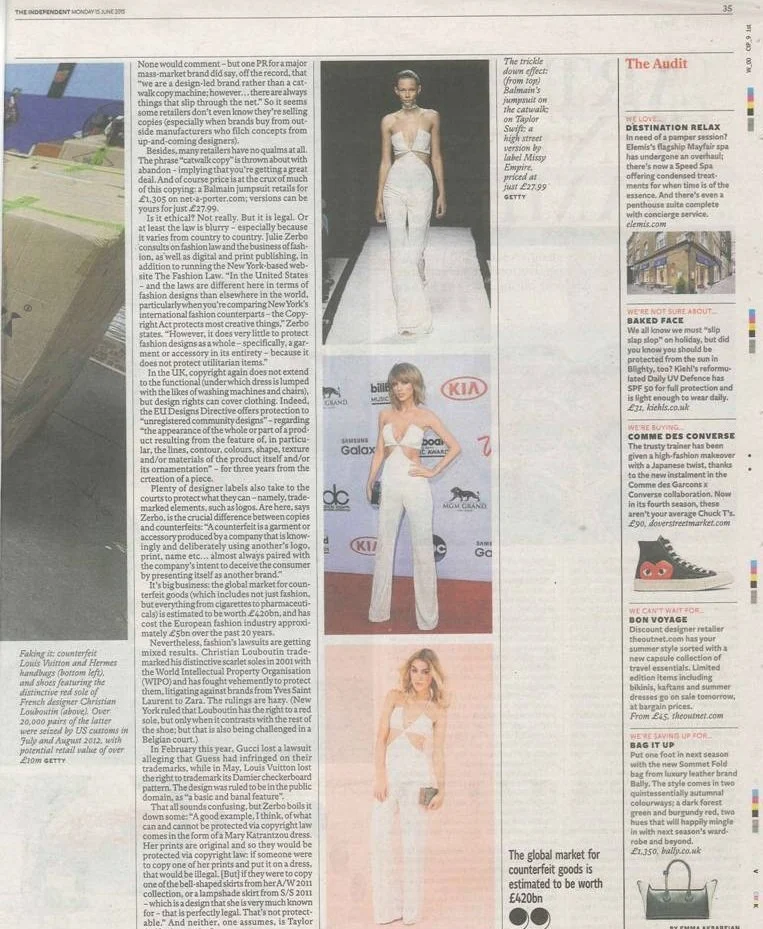 Three women walking on red carpet at fashion event, wearing stylish white outfits.