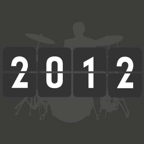A clock displaying the year 2012 with a drummer silhouette in the background.