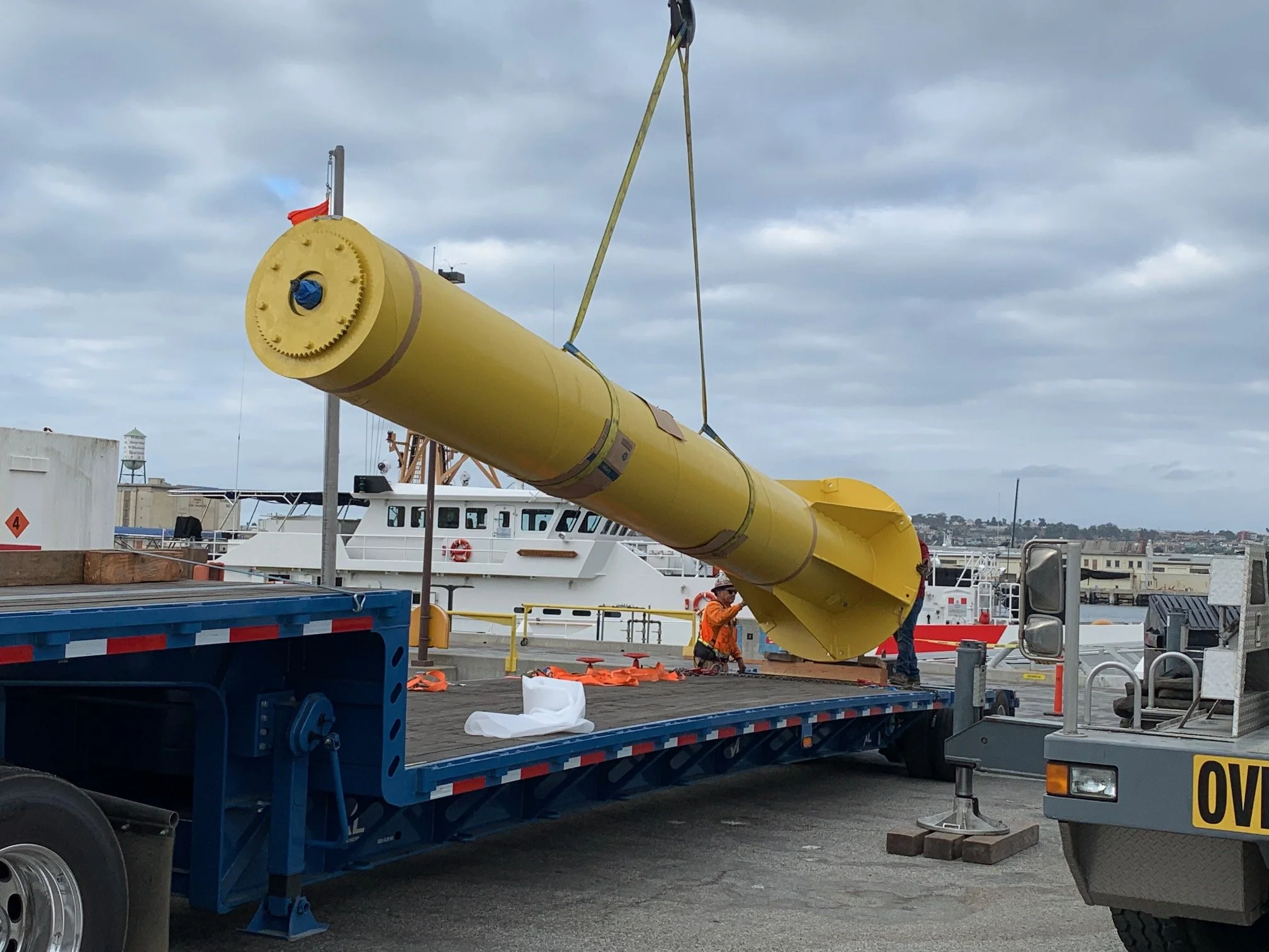 U.S. Coast Guard crane mast being lifted off a flatbed trailer