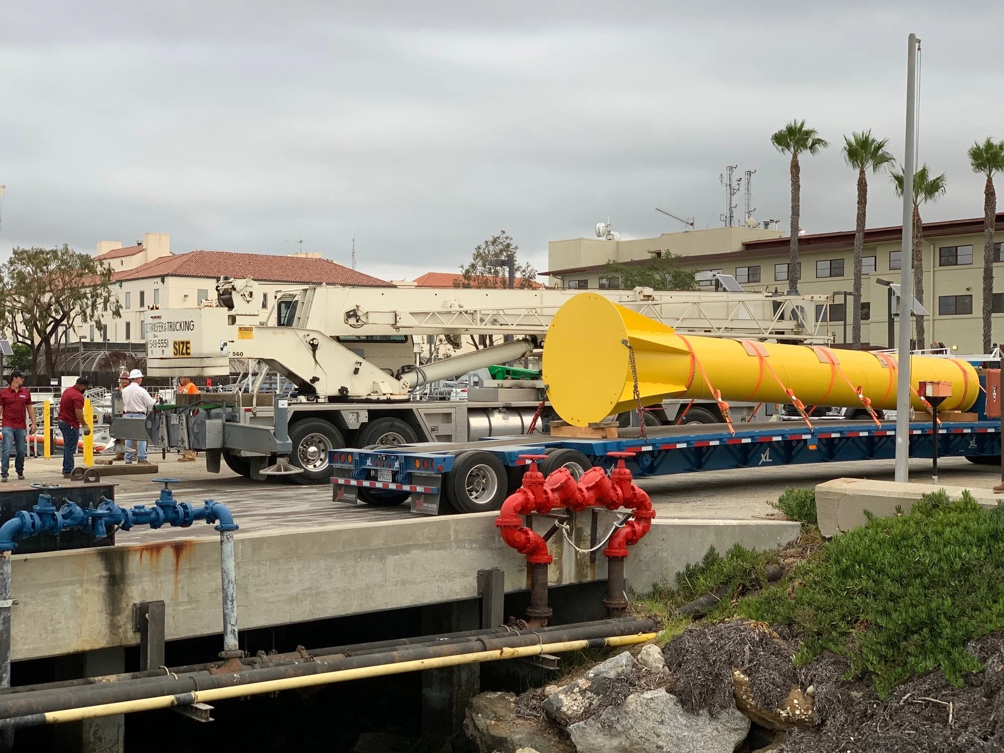 Refinished U.S. Coast Guard crane jib delivered on a flatbed at the pier