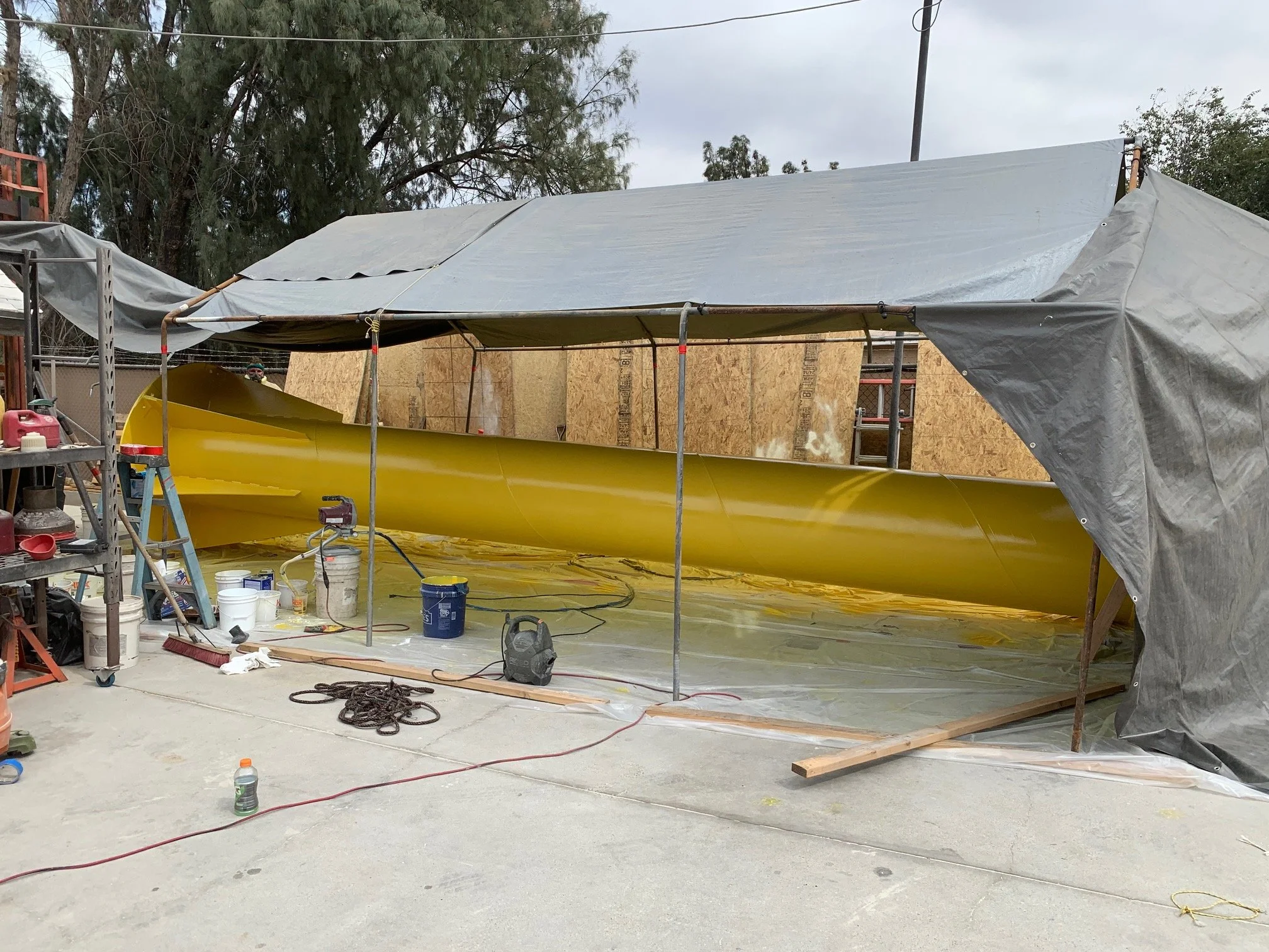 U.S. Coast Guard crane jib with yellow topcoat inside a covered work tent