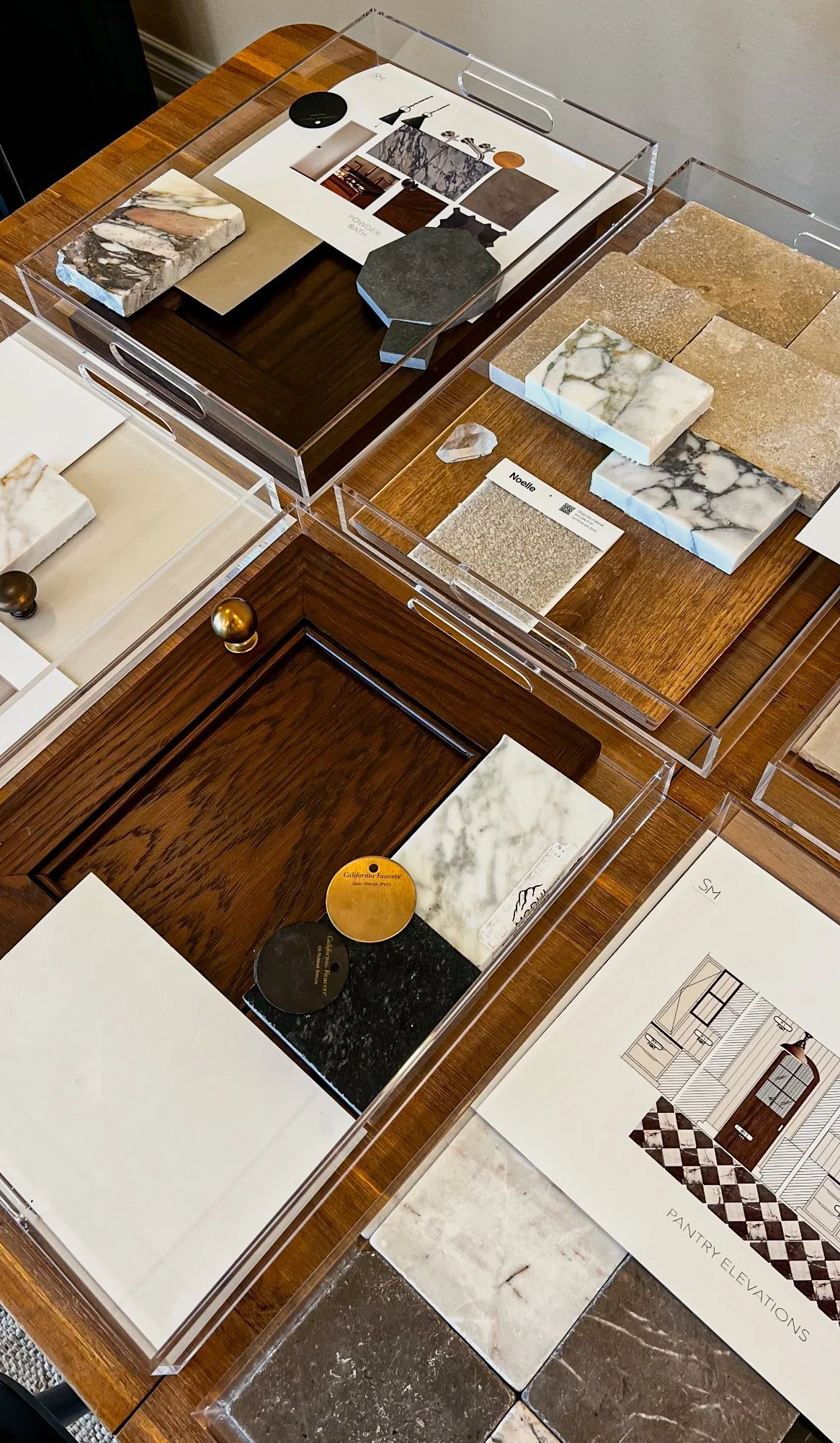 Interior design material selections by Studio Medrano featuring marble and stone samples, wood finishes, hardware and design mood boards.