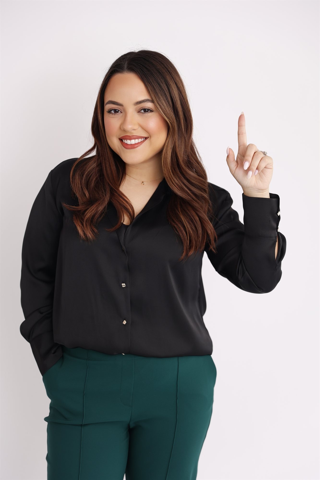 Andrea Cerrada, bilingual Naples FL REALTOR with LUXE Properties, smiling and pointing up