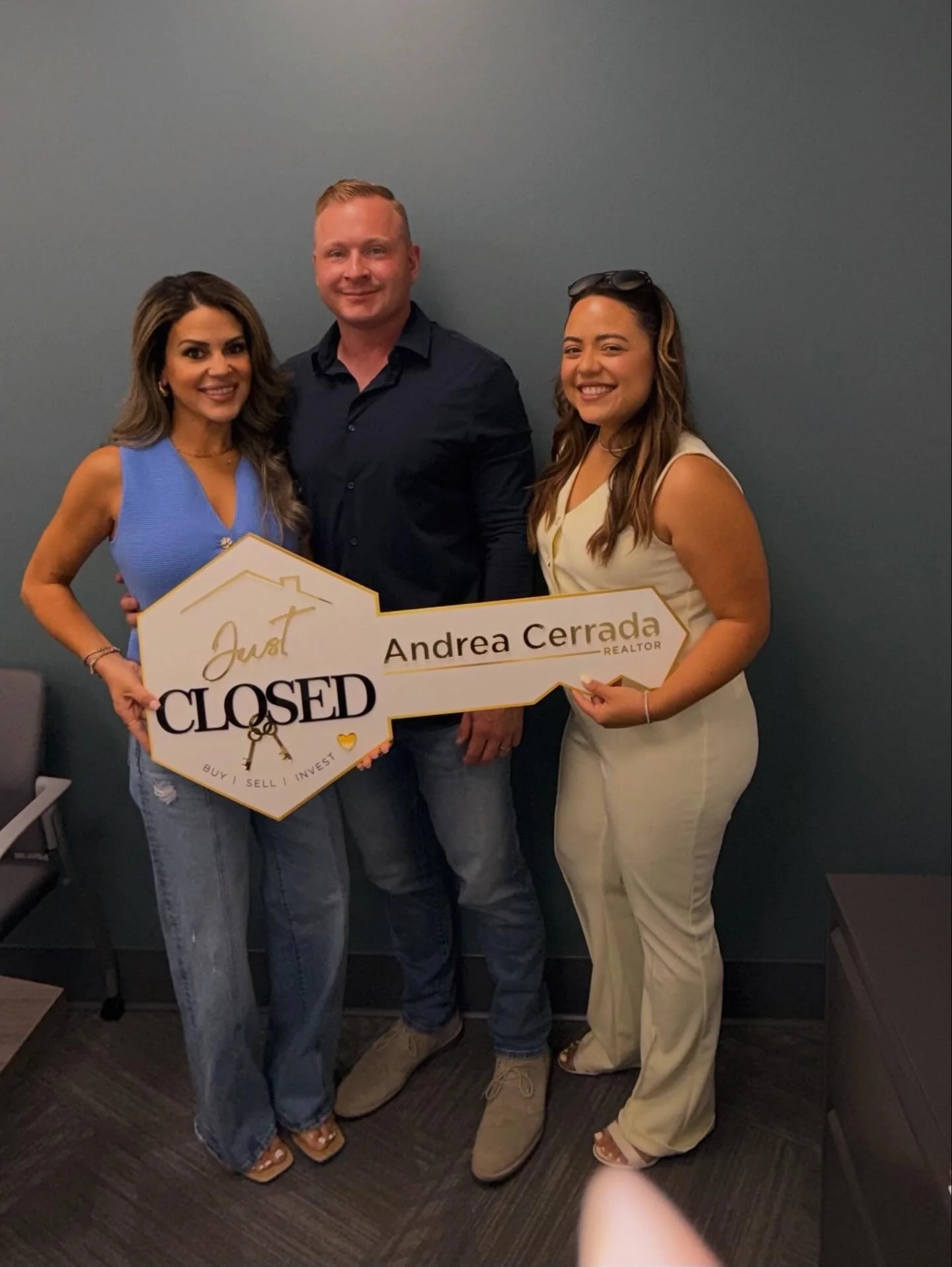 Andrea Cerrada, Naples REALTOR, with happy clients holding a Just Closed sign