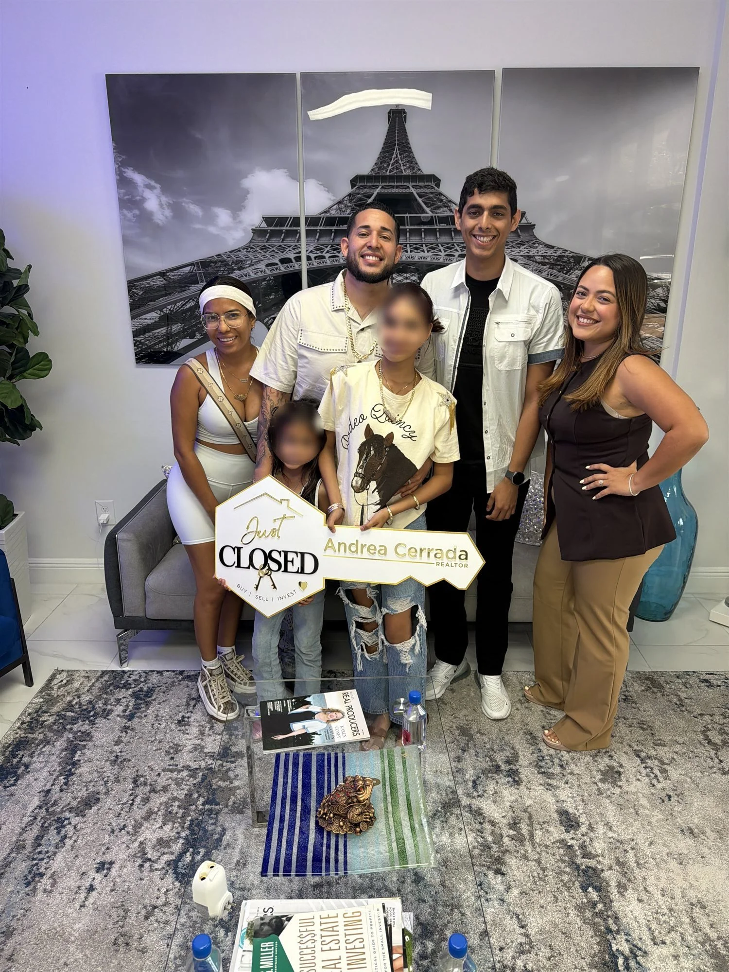 Andrea Cerrada with a family holding a Closed sign in their new Southwest Florida home