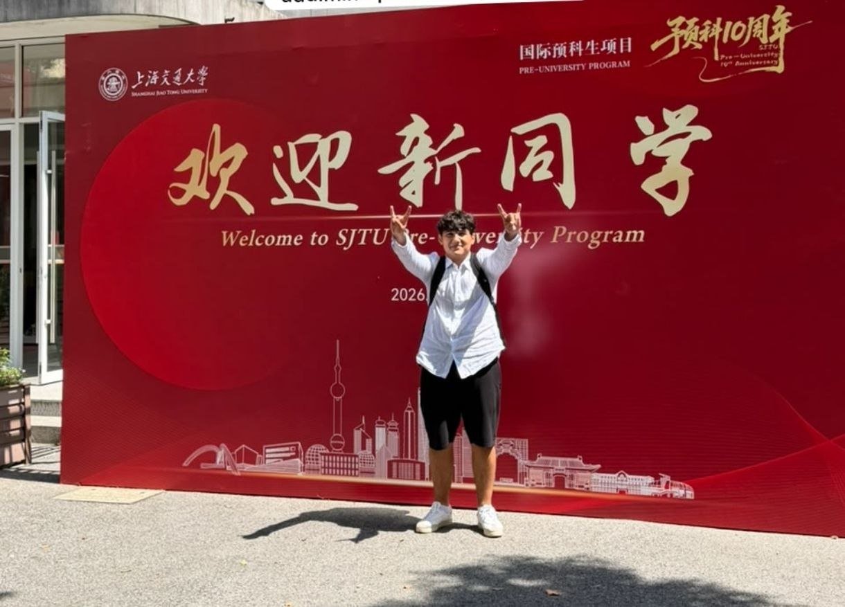Gulu Guliyev in front of the Shanghai Jiao Tong University pre-university programme welcome banner.