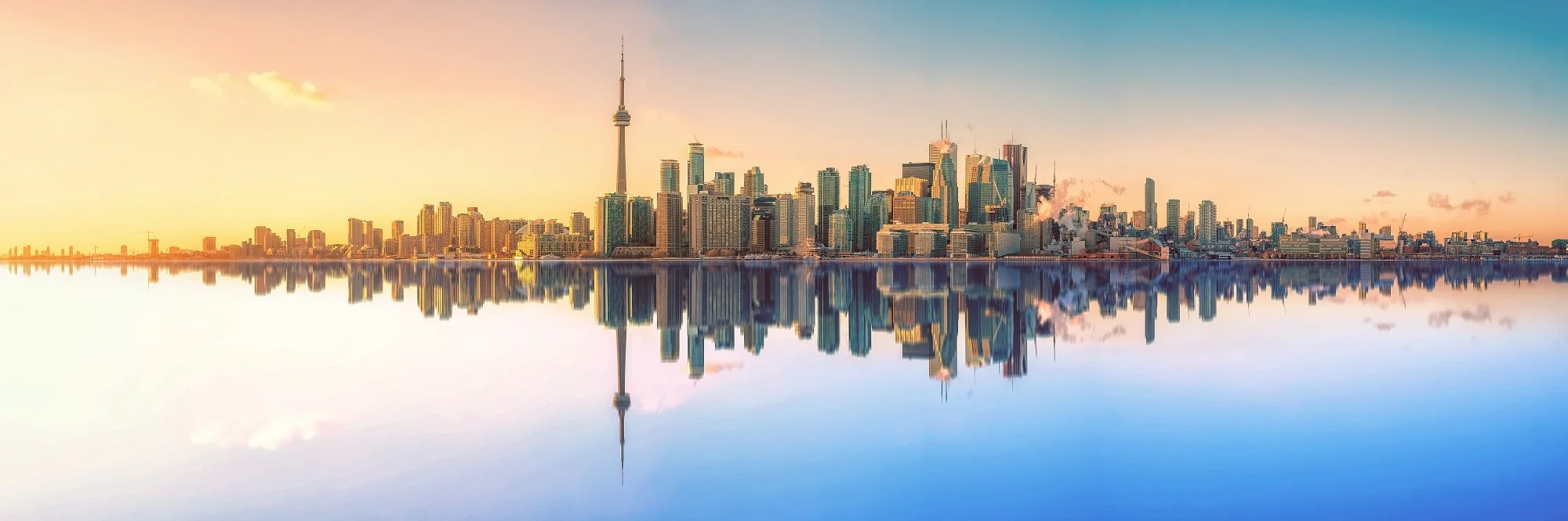 Skyline of Toronto with CN Tower, reflected in water, during sunset