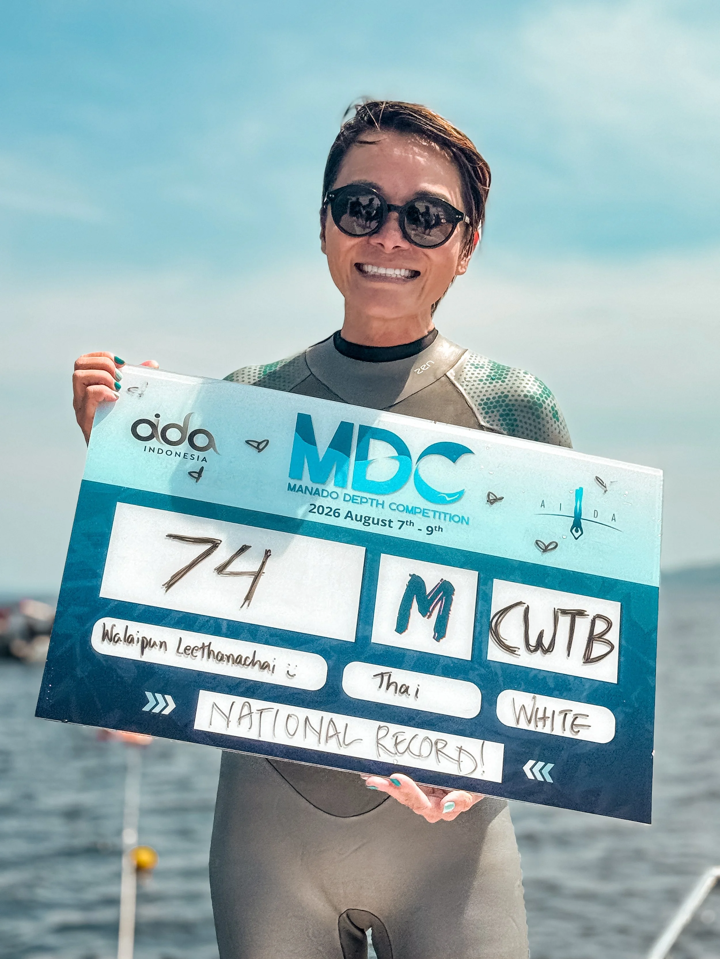 Walaiapun holding a 74 metre freediving competition result board