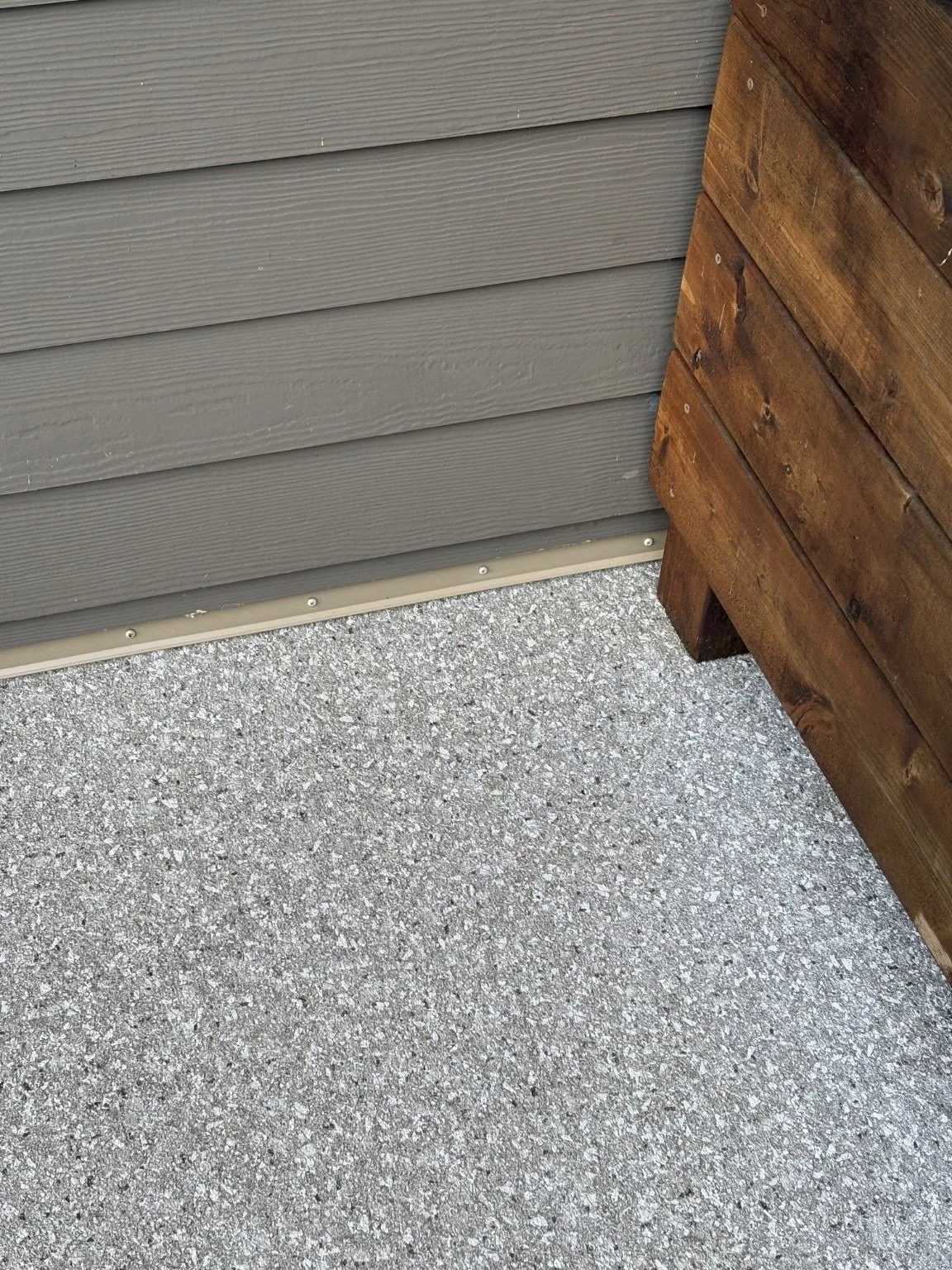 Finished detail: grey patterned vinyl decking at the siding and privacy wall.