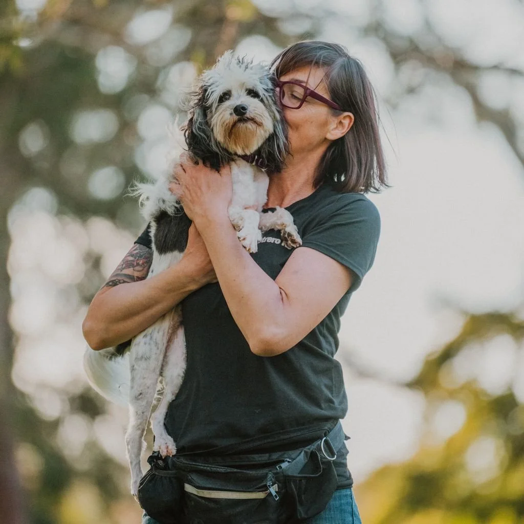 Dog trainer Alexia Rodriguez hugging a small dog, private dog training lessons in Roseville
