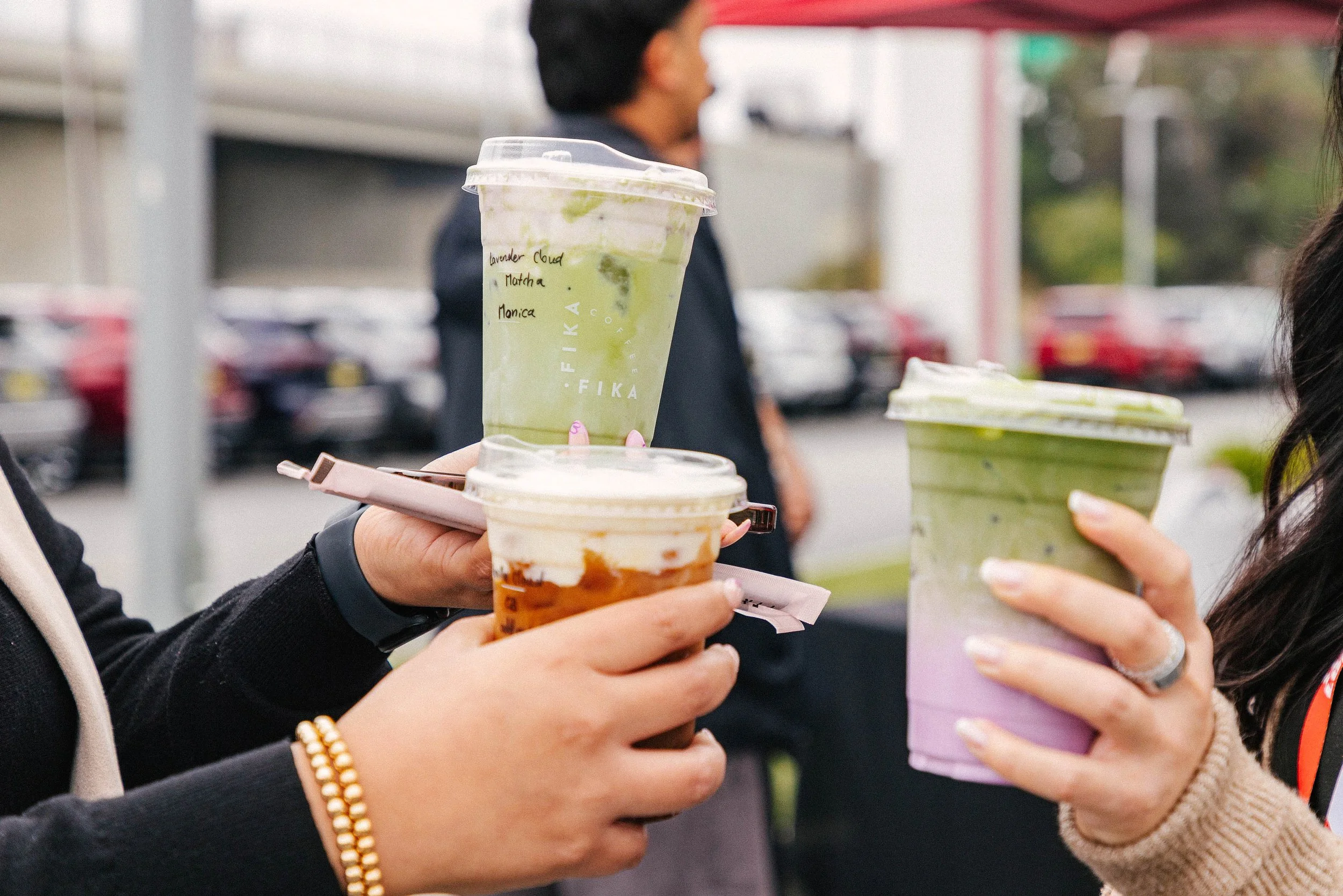 Customers holding Fika drinks