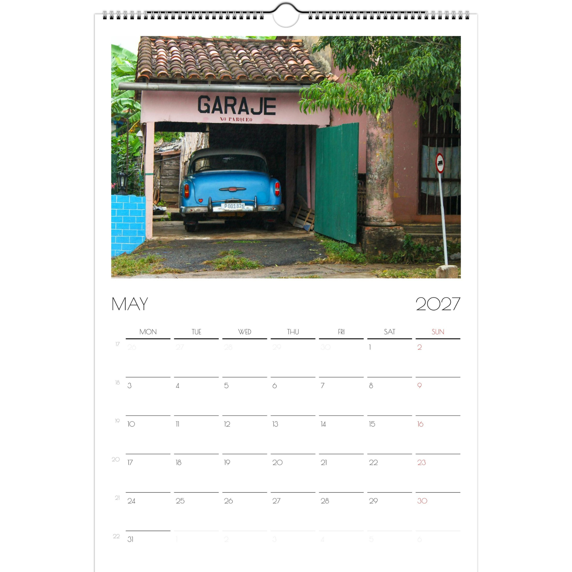 May page of the Classic Cars of Cuba 2027 calendar. The page features a photo of a blue car from the 1950s, parked in an open garage of a pink, stucco building, with bright blue doors.