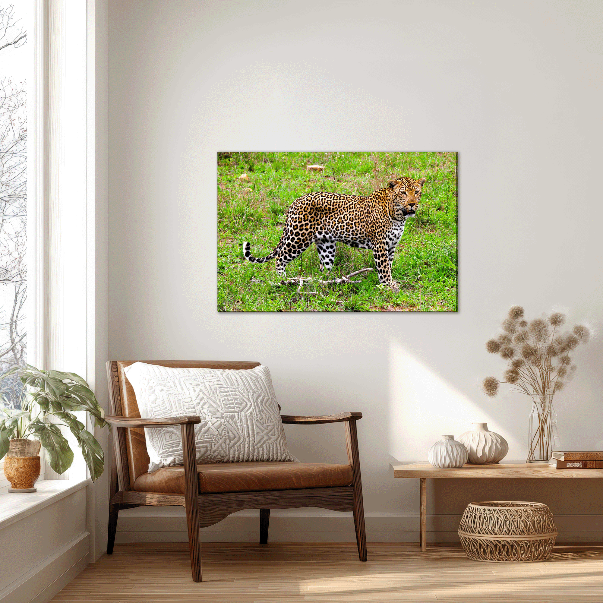 Mockup showing canvas print of a regal leopard, hanging on a wall next to a large window, with a comfy chair underneath.