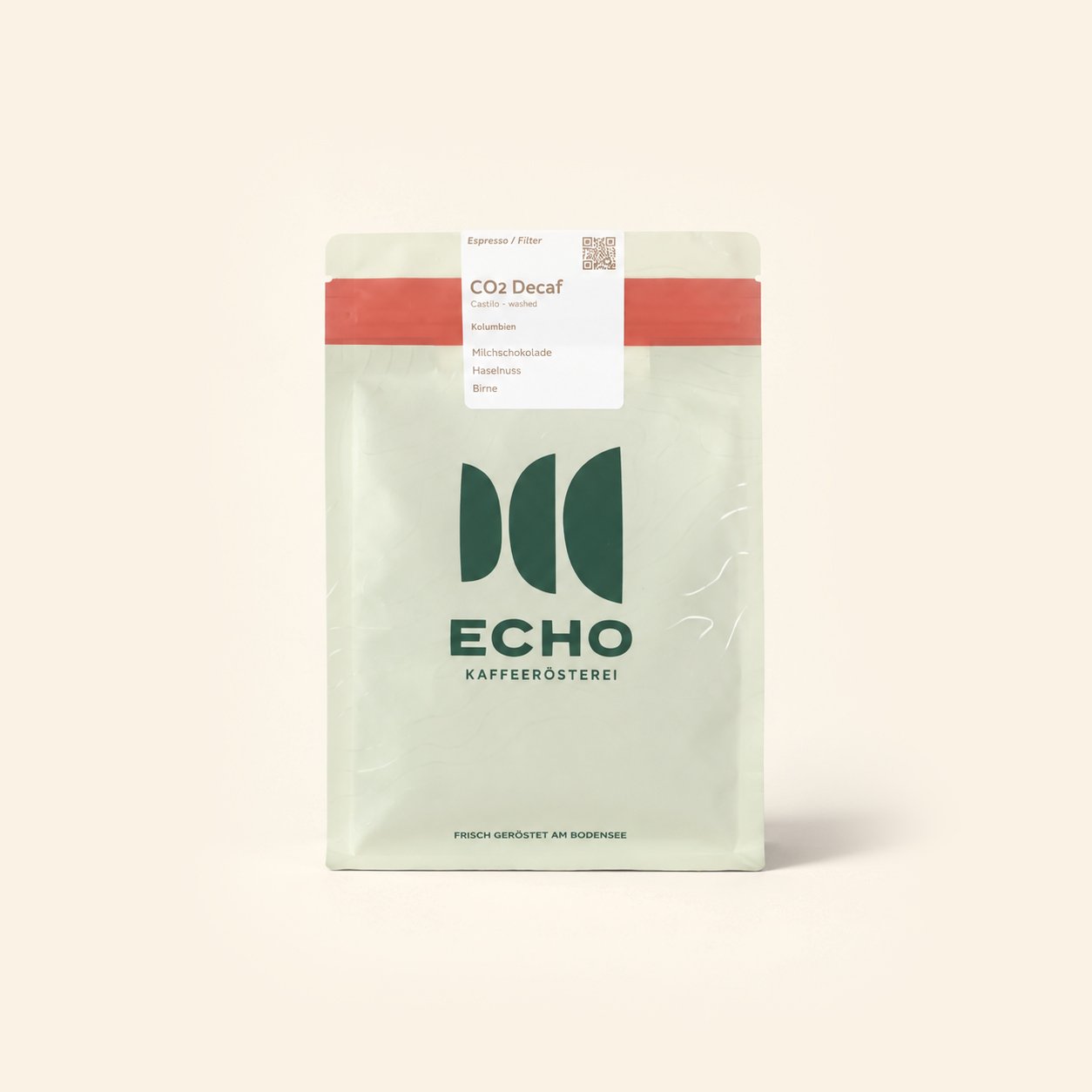 Eine weiße Kaffeepackung mit grünem Logo und rotem Streifen oben, etikettiert als "CO2 Decaf" Kaffee, von der Marke "Echo".