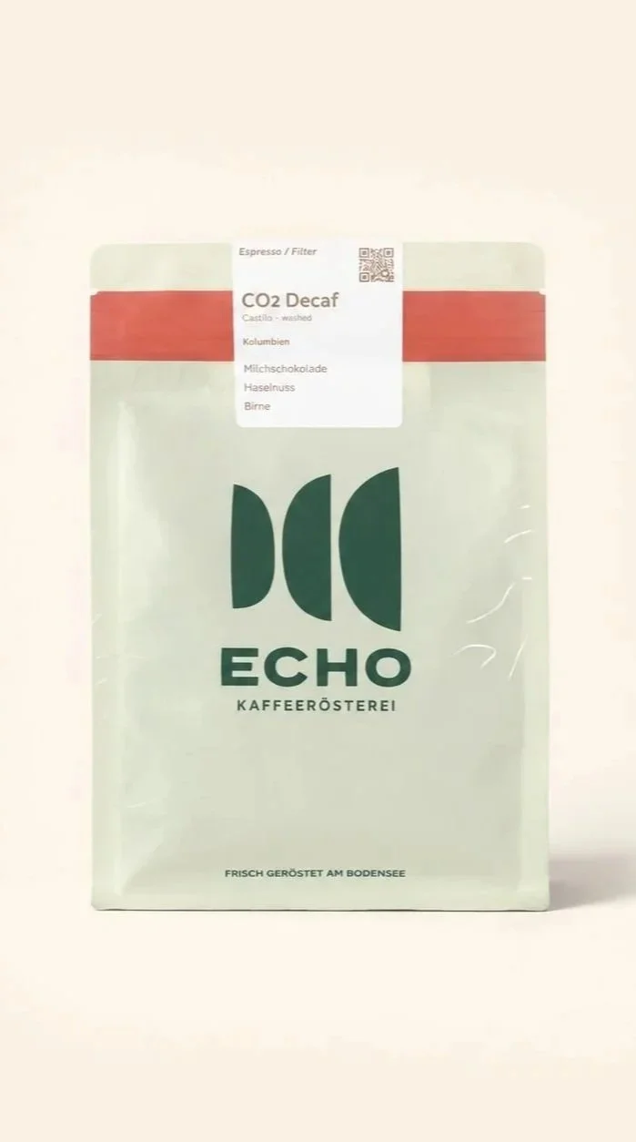Packung Kaffee der Marke ECHO mit CO2 Decaf und Geschmacksrichtungen wie Kastanie, Milchschokolade, Haselnuss und Birne, frontal fotografiert.