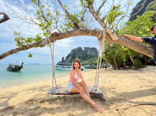 krabi-guest-on-beach-swing-with-boats-and-cliffs.jpg
