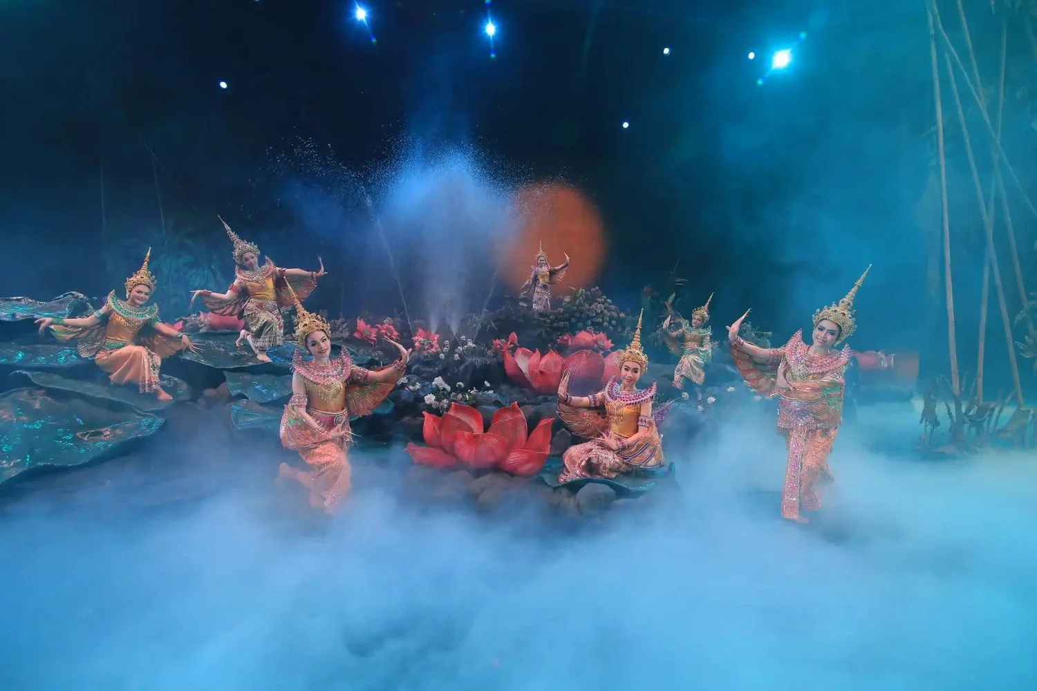 Dancers in Thai costume around giant lotus flowers on stage at Phuket FantaSea