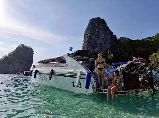 krabi-speedboat-with-guests-in-clear-water-near-limestone-cliffs.jpg