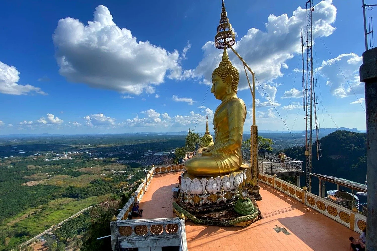 Golden Buddha statue on the summit of Tiger Cave Temple in Krabi with views over the countryside