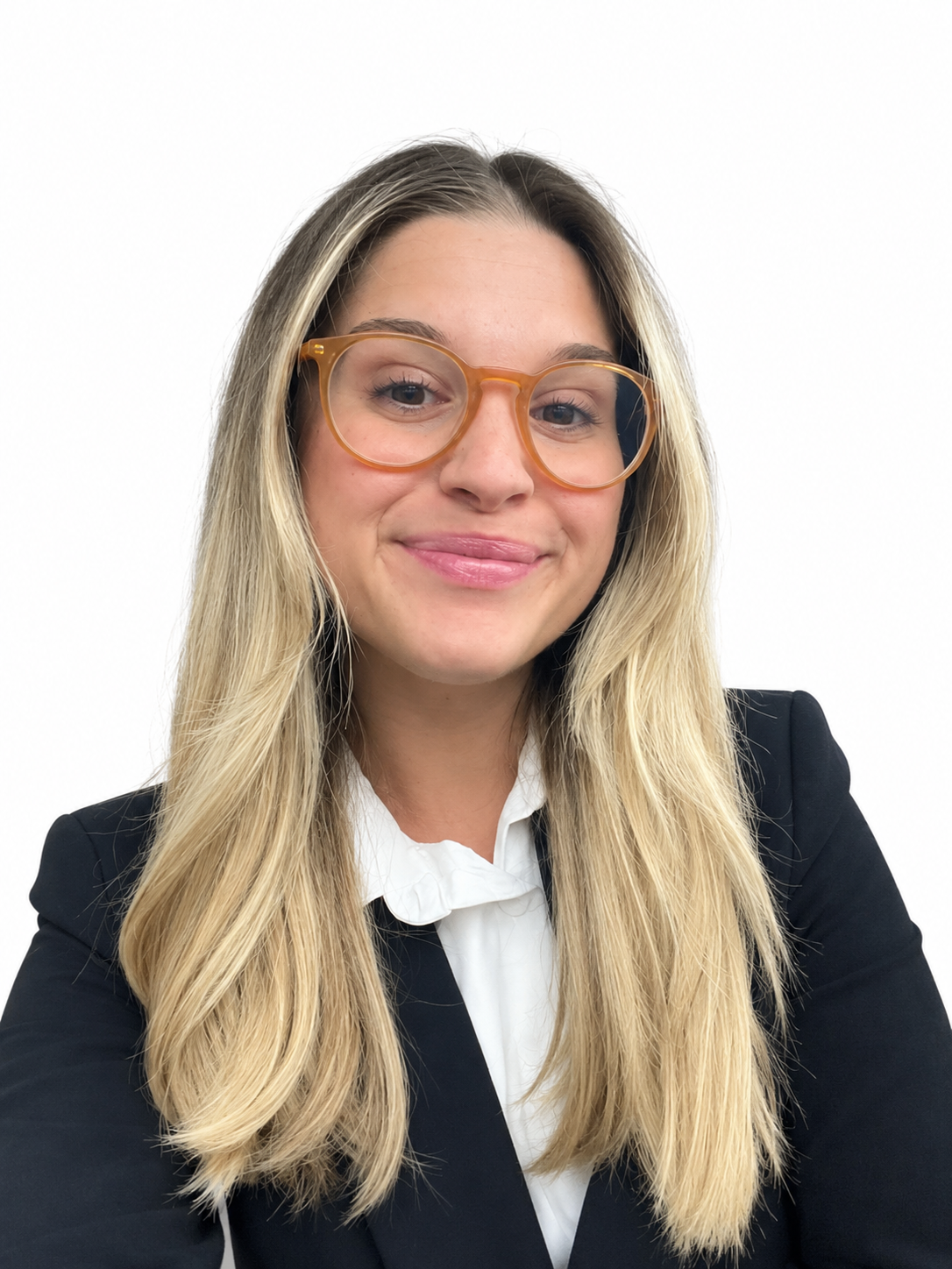 Retrato de una mujer con gafas de armazón color caramelo, pelo largo y rubio, vestida con saco negro y blusa blanca, sonriendo frente a fondo blanco.