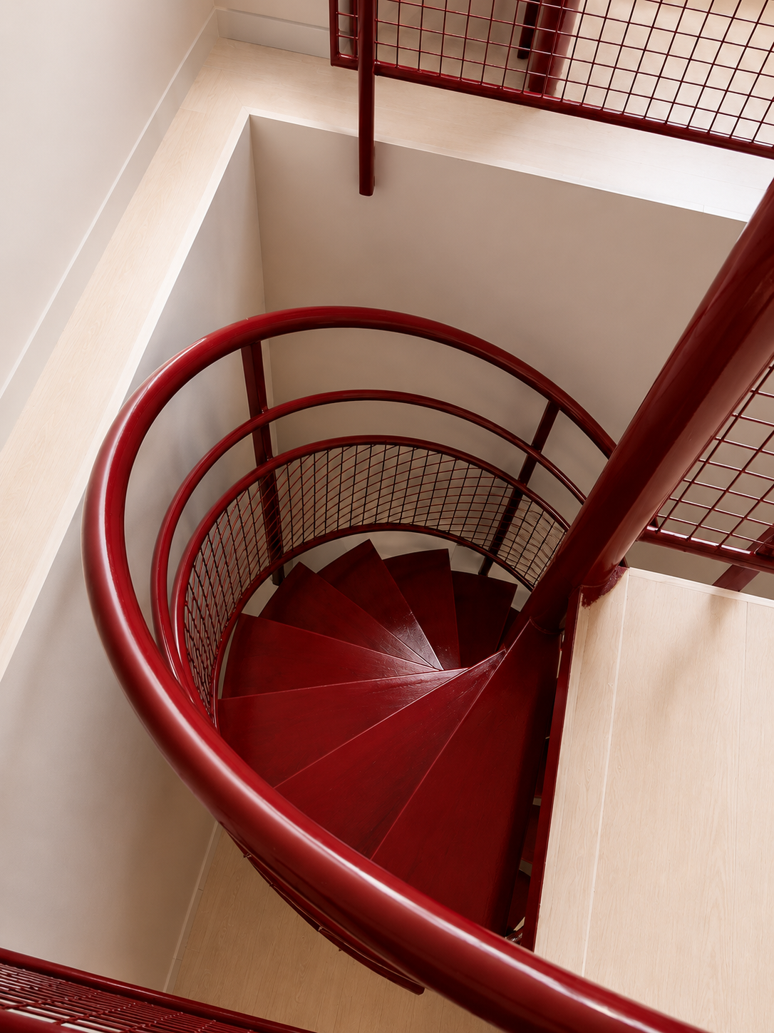 Escalier en spirale rouge vu du dessus dans un bâtiment moderne.